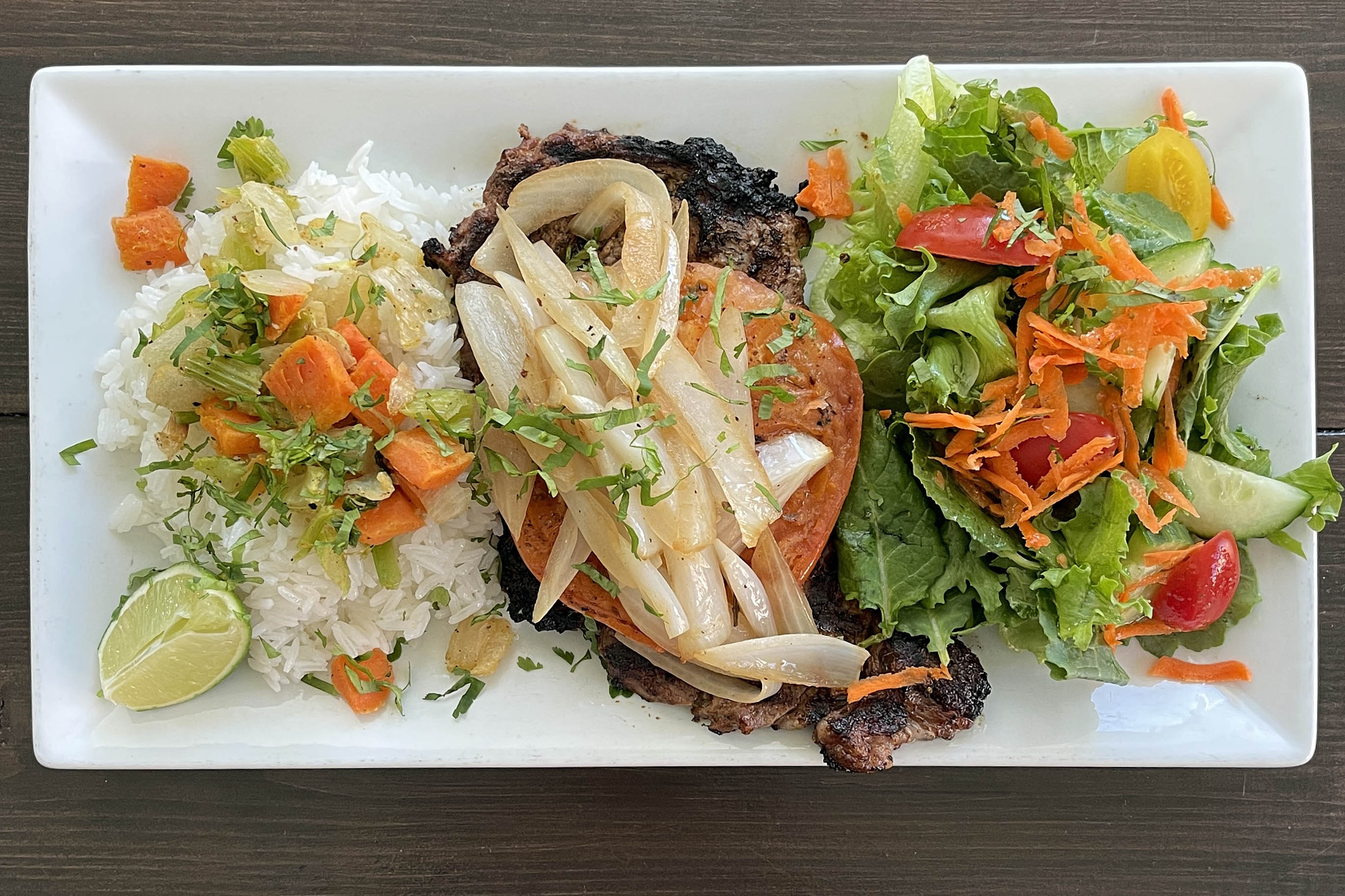 Food Runner Vilma Molina at Mera's Kitchen Collective brings El Salvadoran Bistec Encebolladas, a celebratory dish of grilled steak and marinated vegetables, to the restaurant's menu starting March 24.