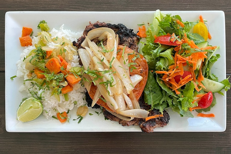Food Runner Vilma Molina at Mera's Kitchen Collective brings El Salvadoran Bistec Encebolladas, a celebratory dish of grilled steak and marinated vegetables, to the restaurant's menu starting March 24.