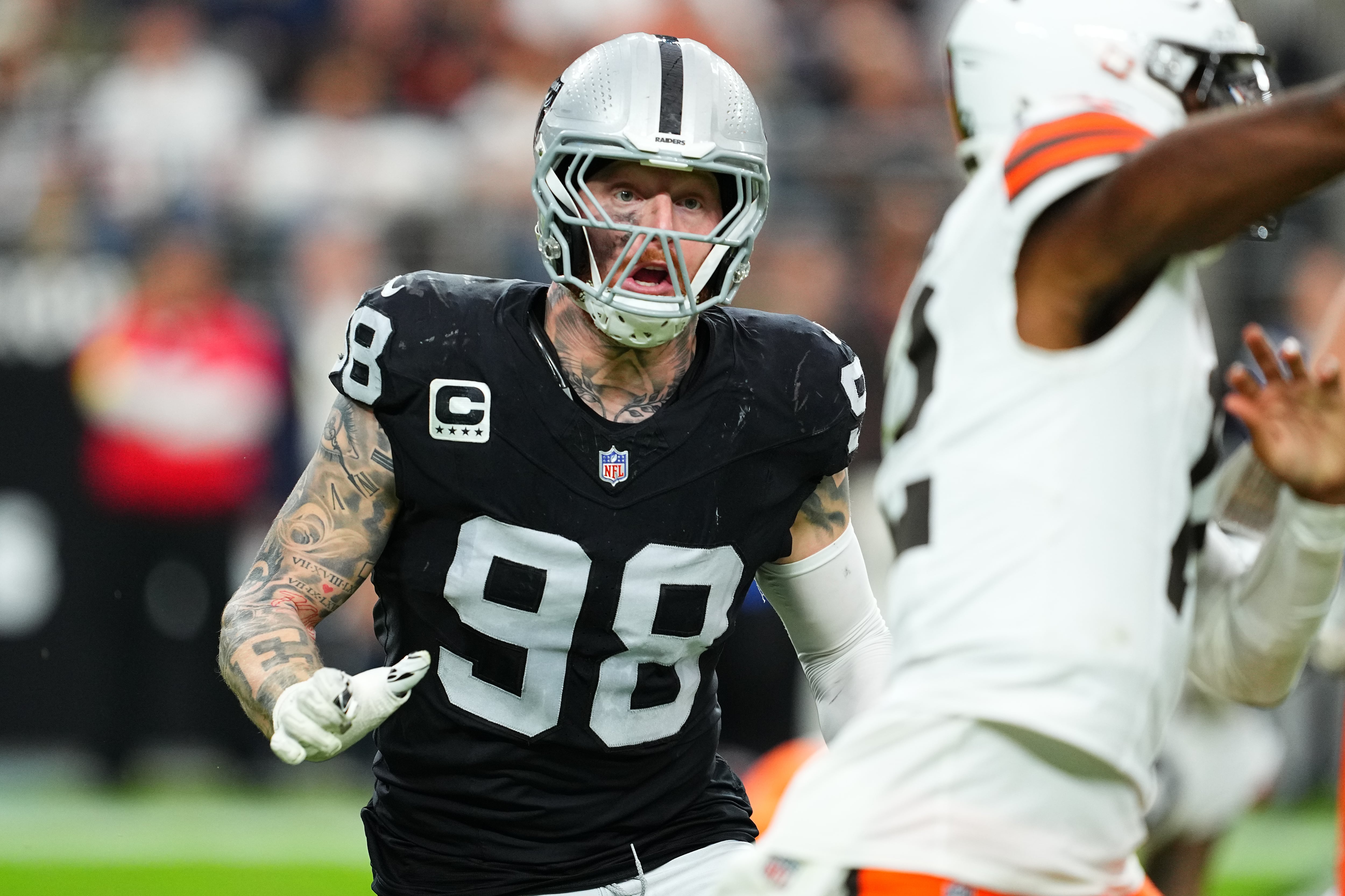 Maxx Crosby in the Las Vegas Raiders black number 98 jersey rushing an opponent