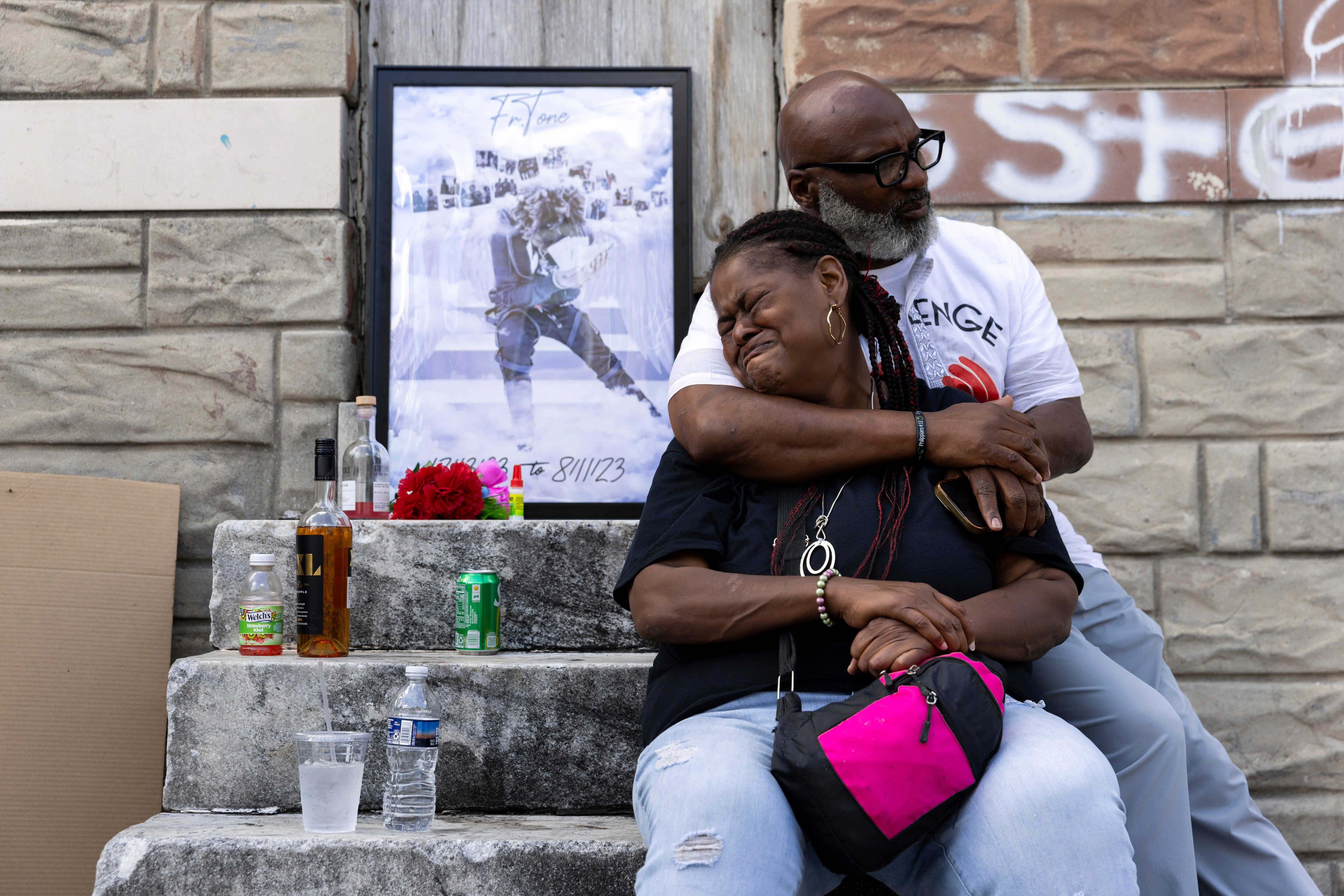 Antonio Lee’s mother is comforted while mourning her son at a vigil, Friday, Aug. 18, 2023, in Baltimore. Lee, 19, was shot and killed while squeegeeing in Baltimore. Lee and childhood friend Antonio Moore grew up together in the streets of east Baltimore, surrounded by poverty and gun violence. But only one would make it out alive. Moore is a successful real estate investor and marketing consultant. Lee was shot and killed last summer, four months before his 20th birthday.