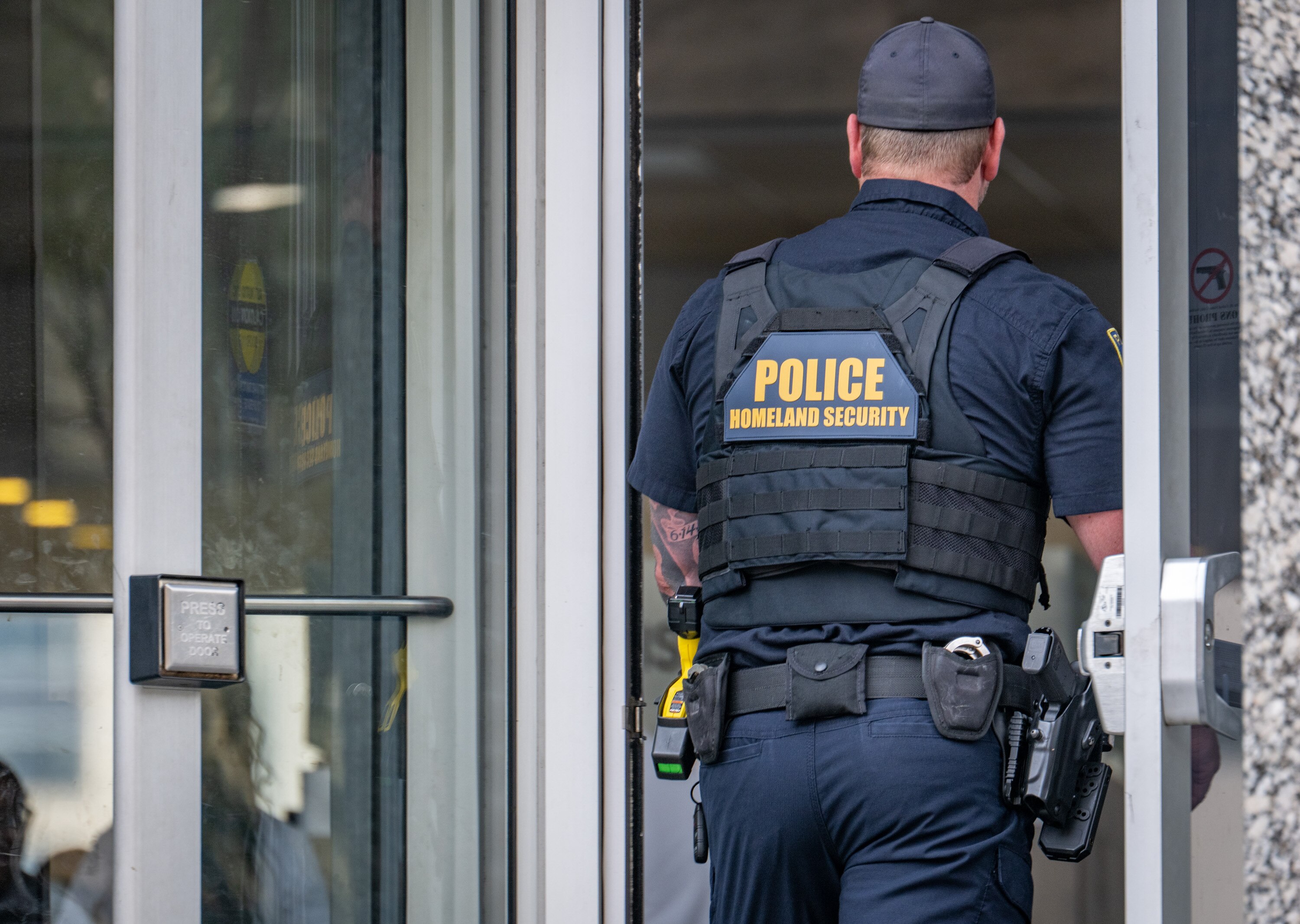 Wednesday, Aug. 13, 2025 — A Dept. of Homeland Security officer enters the Fallon Federal Building.