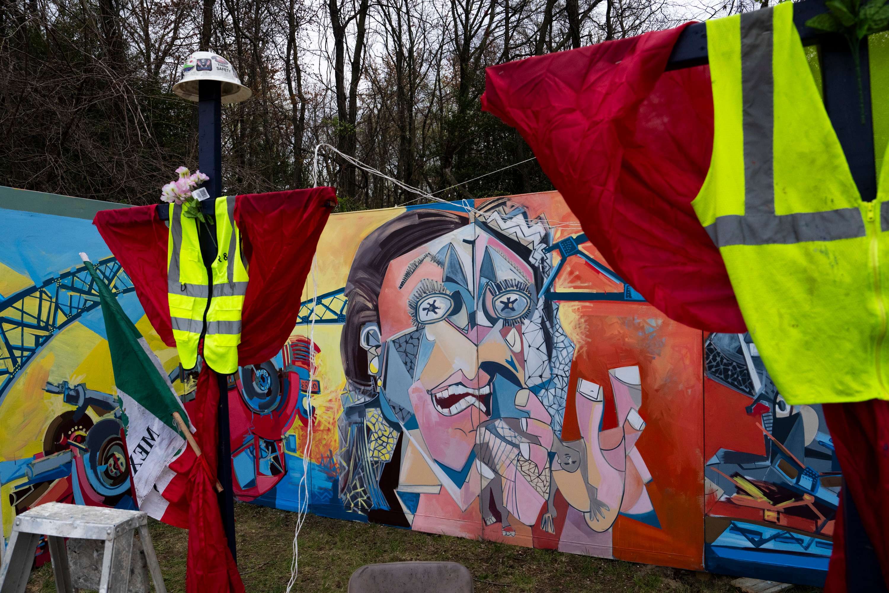 A memorial site to honor the construction workers who lost their lives in the collapse of the Key Bridge sits on the side of the road right before the blockade to Fort Armistead Park. Roberto Marquez, an artist from Dallas, TX, painted a mural in their honor as well as painted their names on several crosses dotting the perimeter of flowers, candles, and othe mementos of remembrance. Members of the community honored the victims through prayer and song on April 6, 2024.