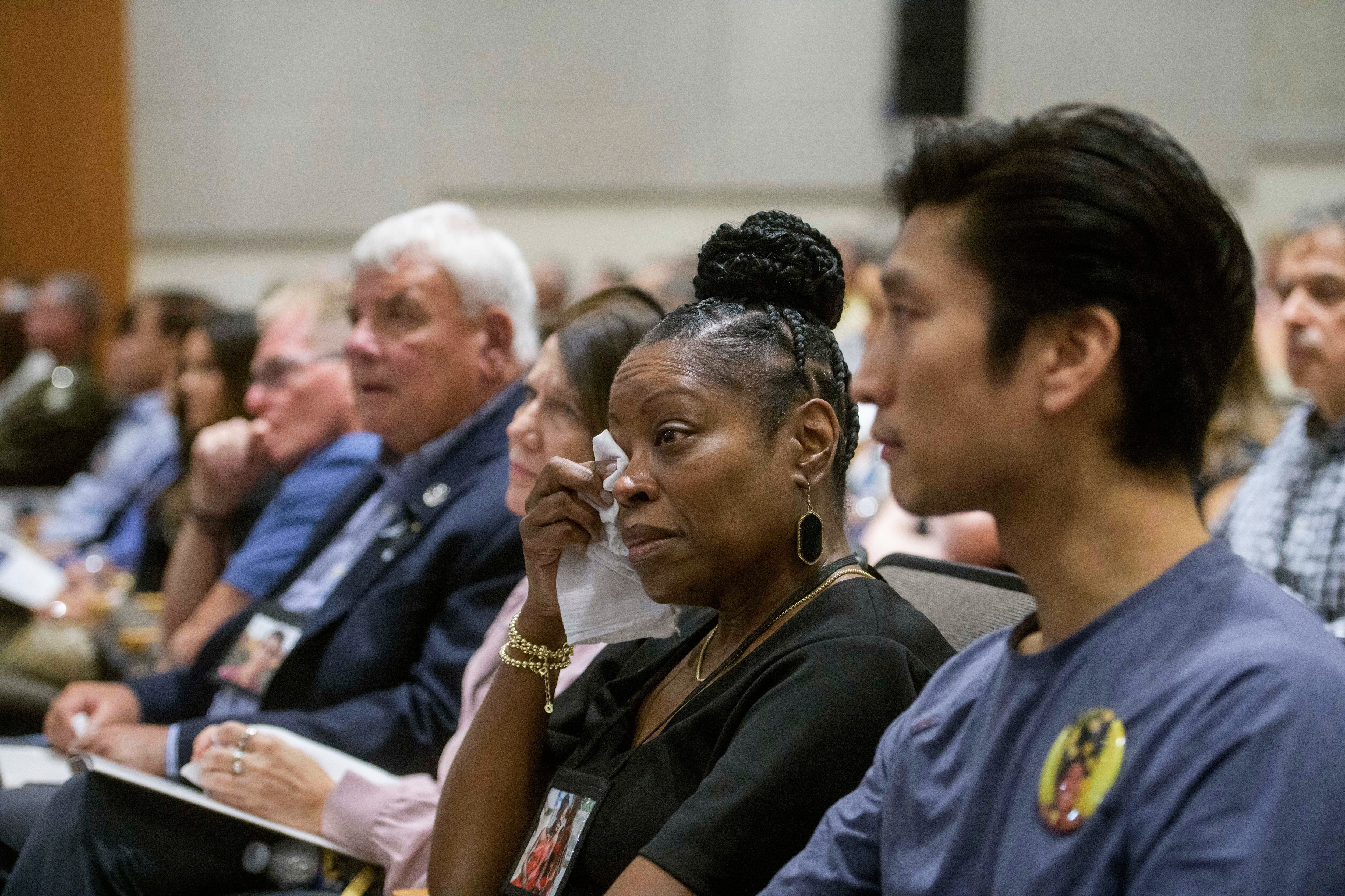 Gwen Duggins, second from right, whose daughter Kiah Duggins perished on American Airlines flight 5342 in a collision with a U.S. military helicopter, wipes the tears from her eyes while listening to the audio of the flight radio transmissions during the NTSB fact-finding hearing on the DCA midair collision accident, at the National Transportation and Safety Board boardroom, Wednesday, July 30, 2025, in Washington. (AP Photo/Rod Lamkey, Jr.)