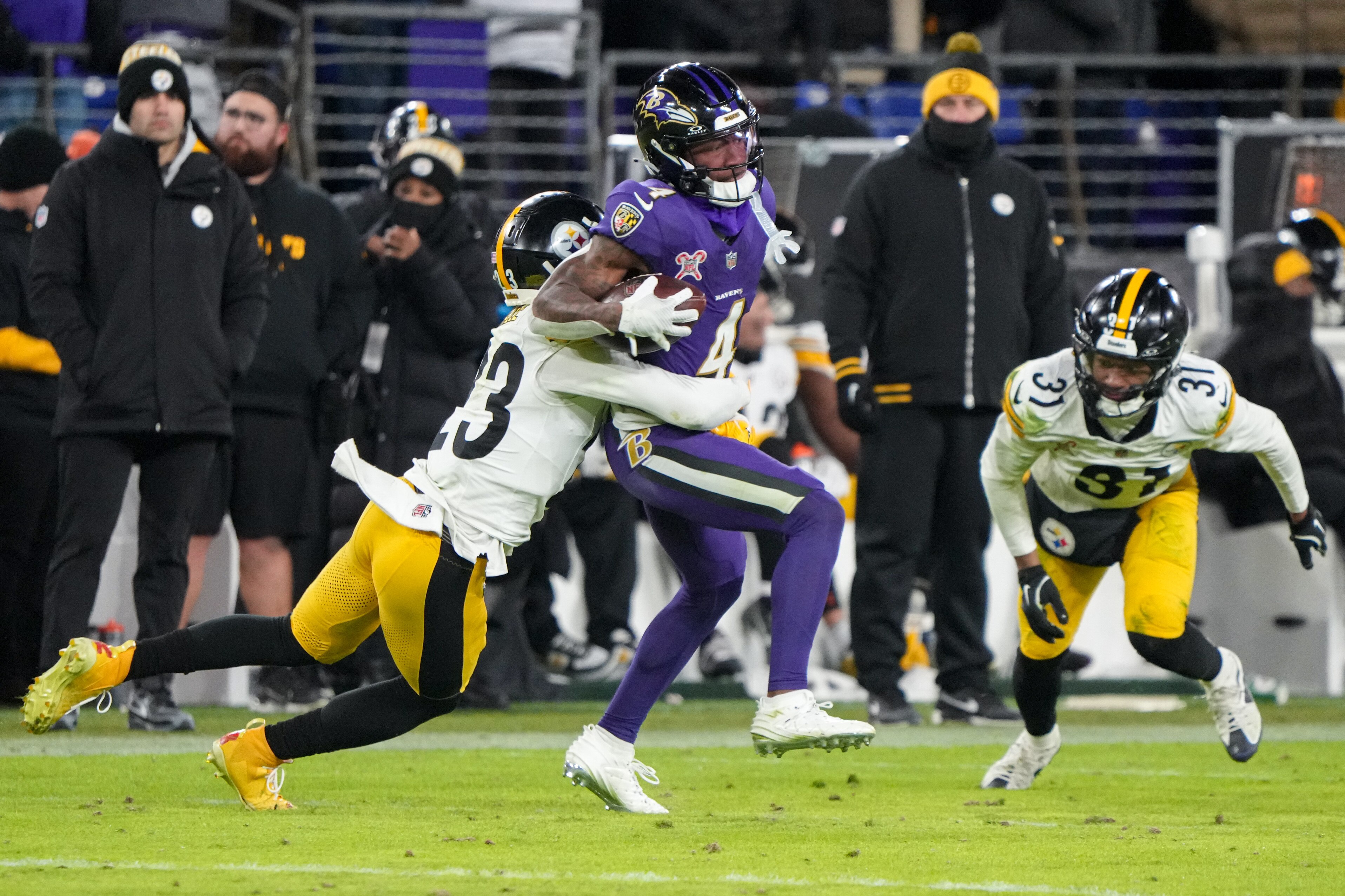 Baltimore Ravens wide receiver Zay Flowers (4) tries to shed a tackle after catching a pass during against the Steelers.
