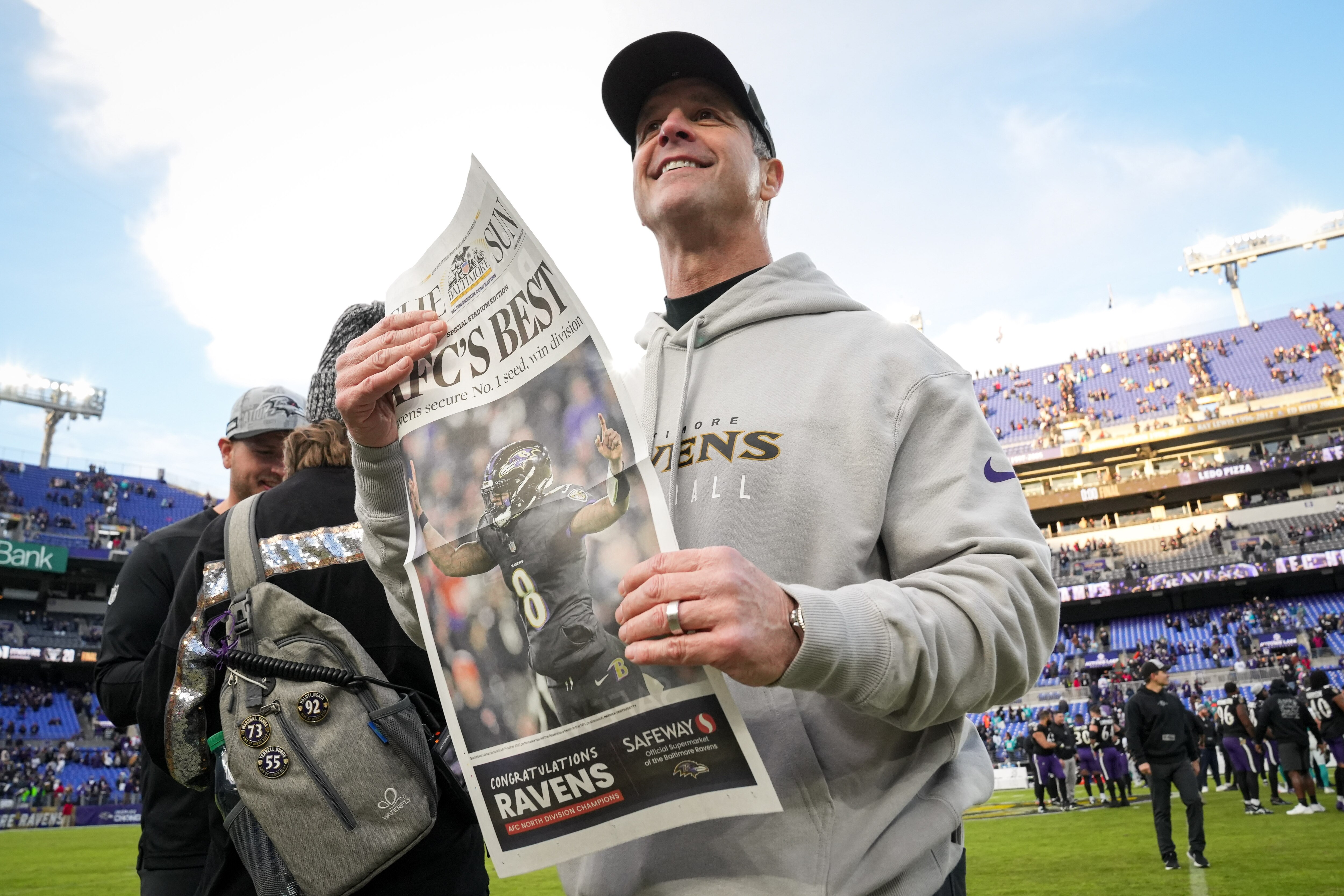 Baltimore Ravens head coach John Harbaugh walks off the field holding a special edition of the Baltimore Sun declaring the Ravens the AFC’s best team after they beat the Miami Dolphins at M&T Bank Stadium on Sunday, Dec. 31, 2023. The Ravens won, 56-19, to secure the best record in the AFC.