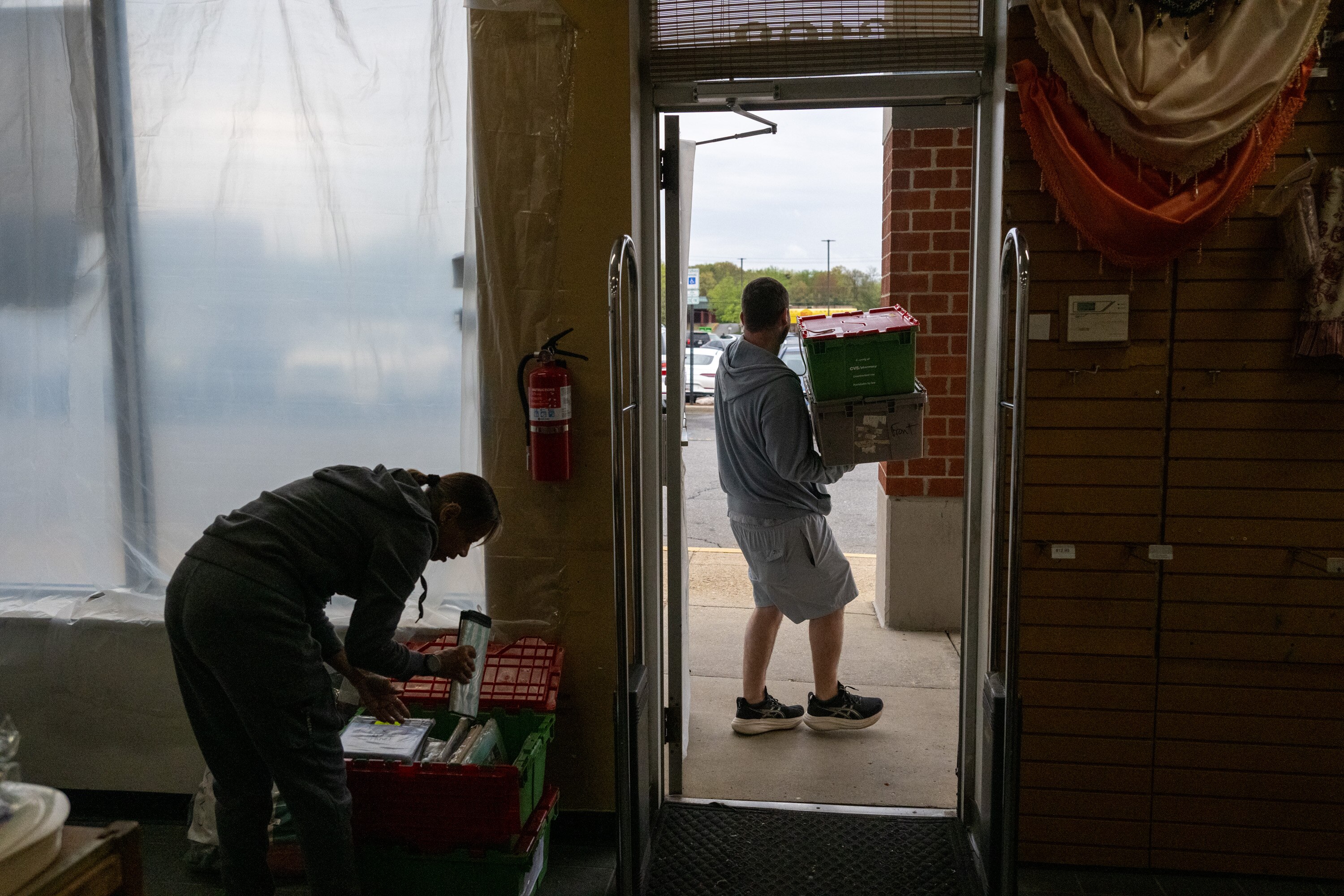 Linen World owner Jason Gaister carries out boxes of unsold inventory to be donated to charity as the family-owned business shuts its doors after 37 years.