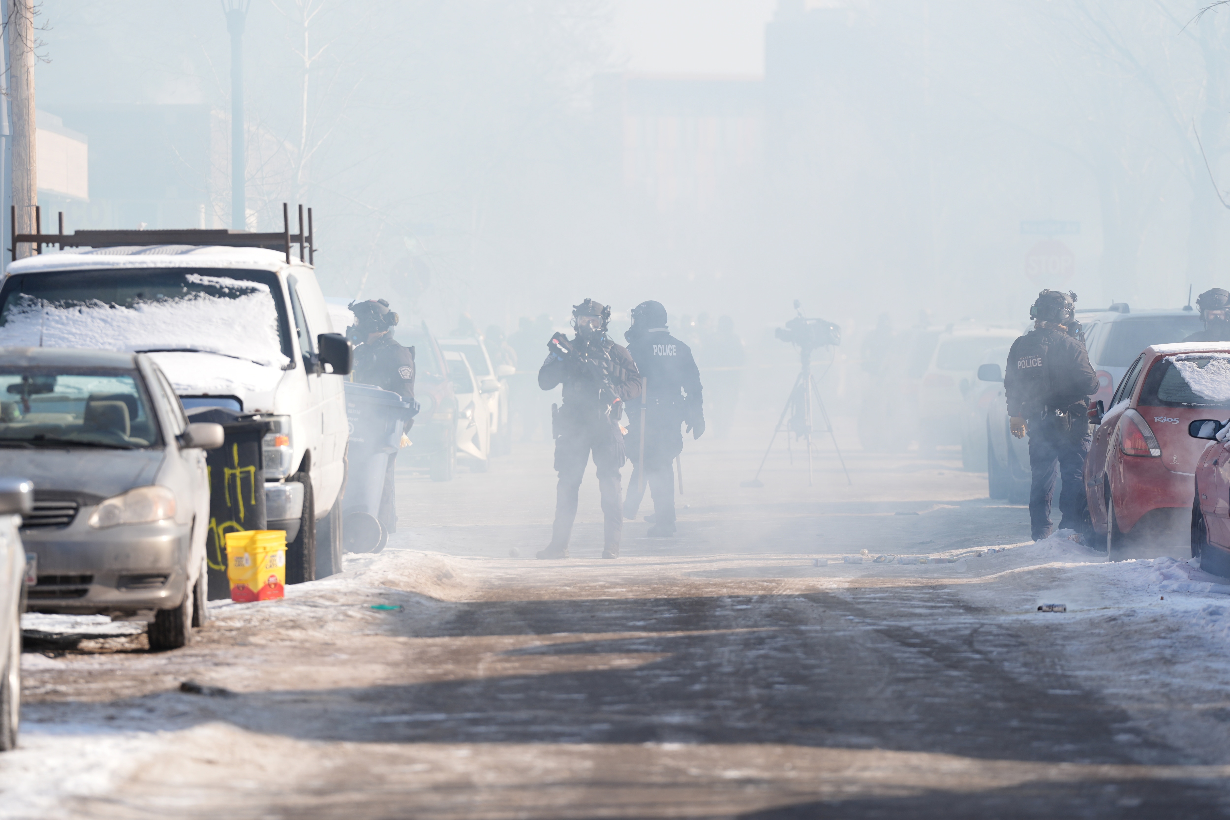 Federal immigration officers deploy tear gas at protesters after a shooting Saturday in Minneapolis.