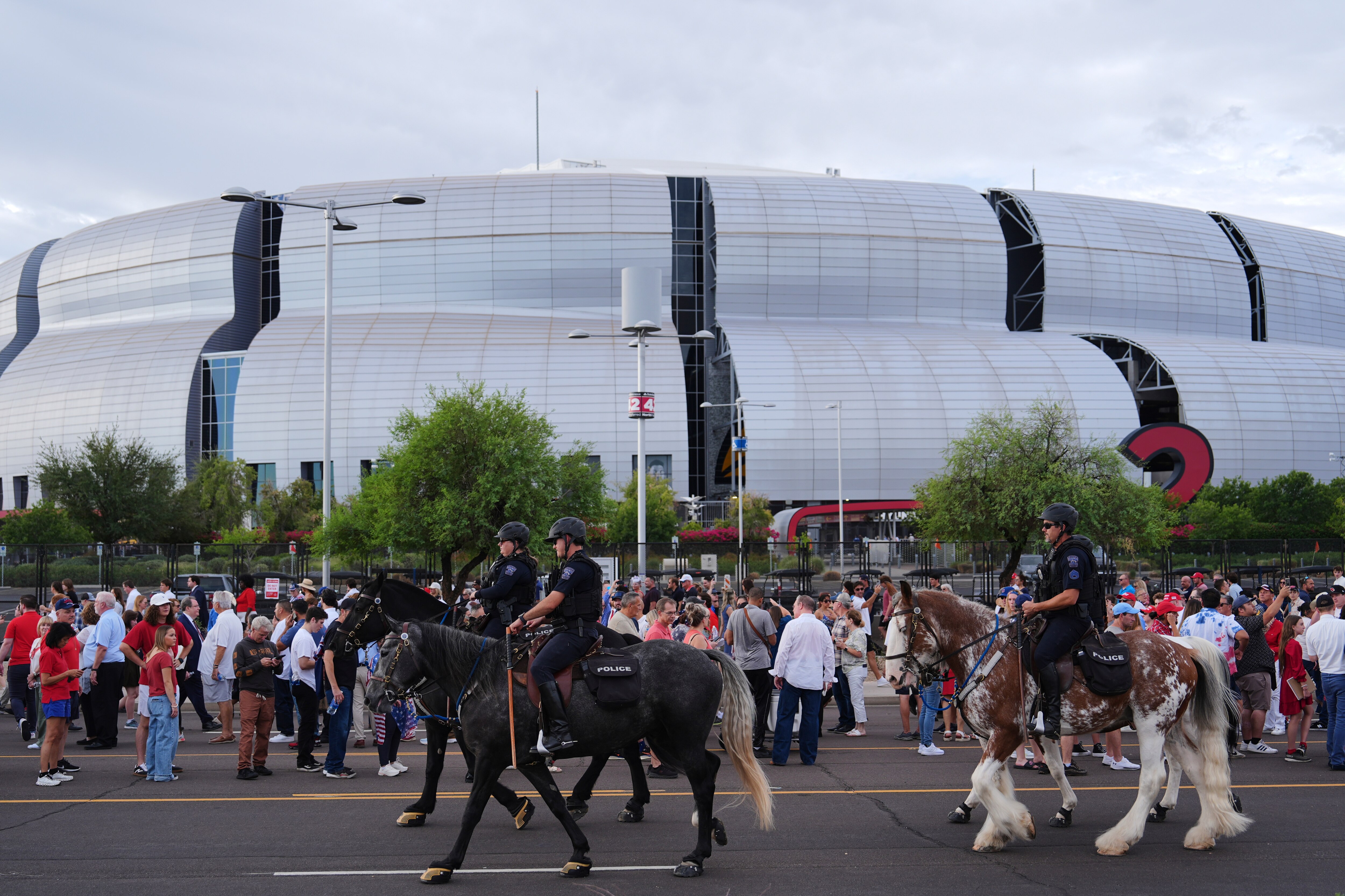 Police ride around on horses outside before a memorial for conservative activist Charlie Kirk, Sunday, Sept. 21, 2025, at State Farm Stadium in Glendale, Ariz.