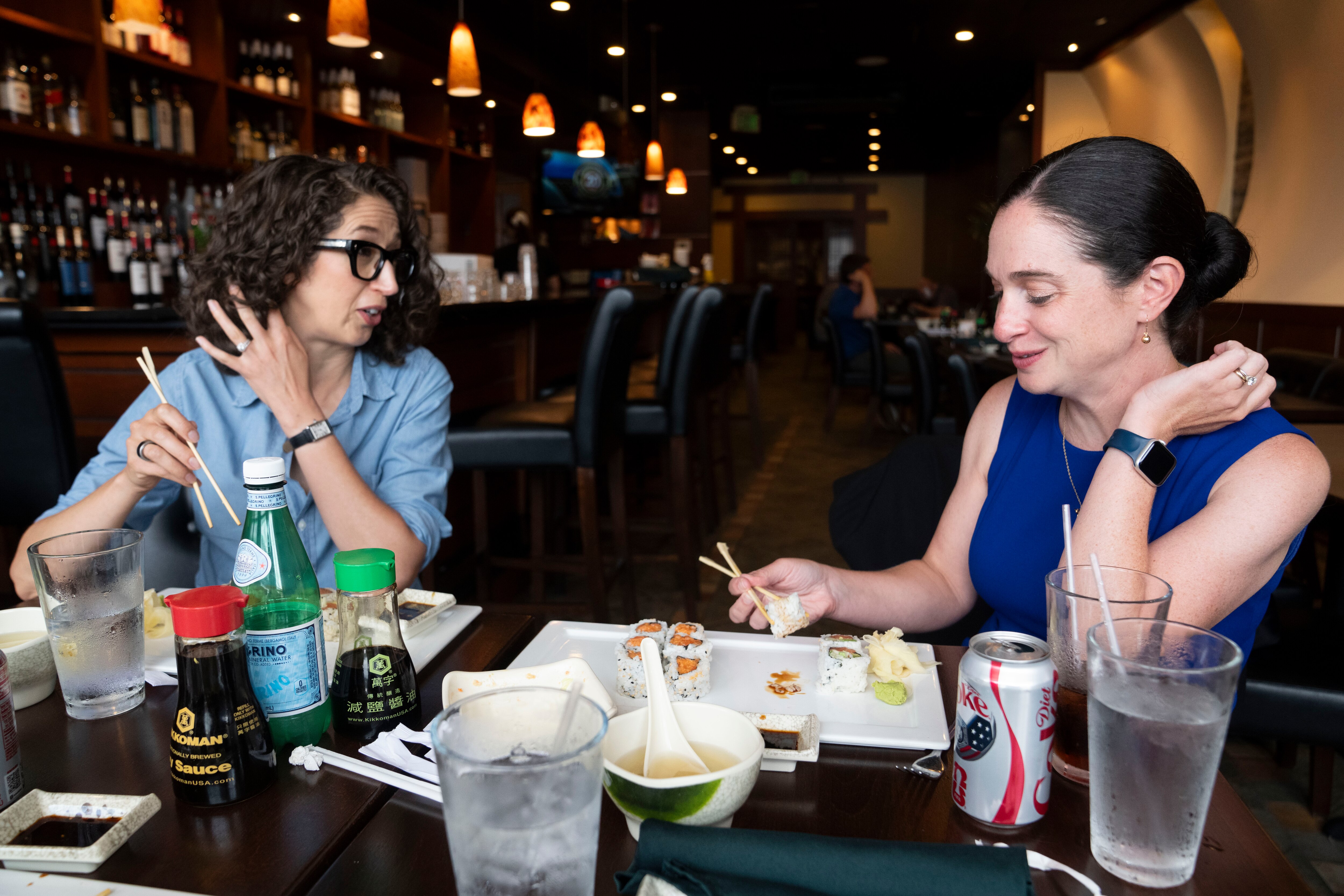 Brooke Nevils and Sarah David talk to each other while eating lunch at Sushi Hana in Towson.