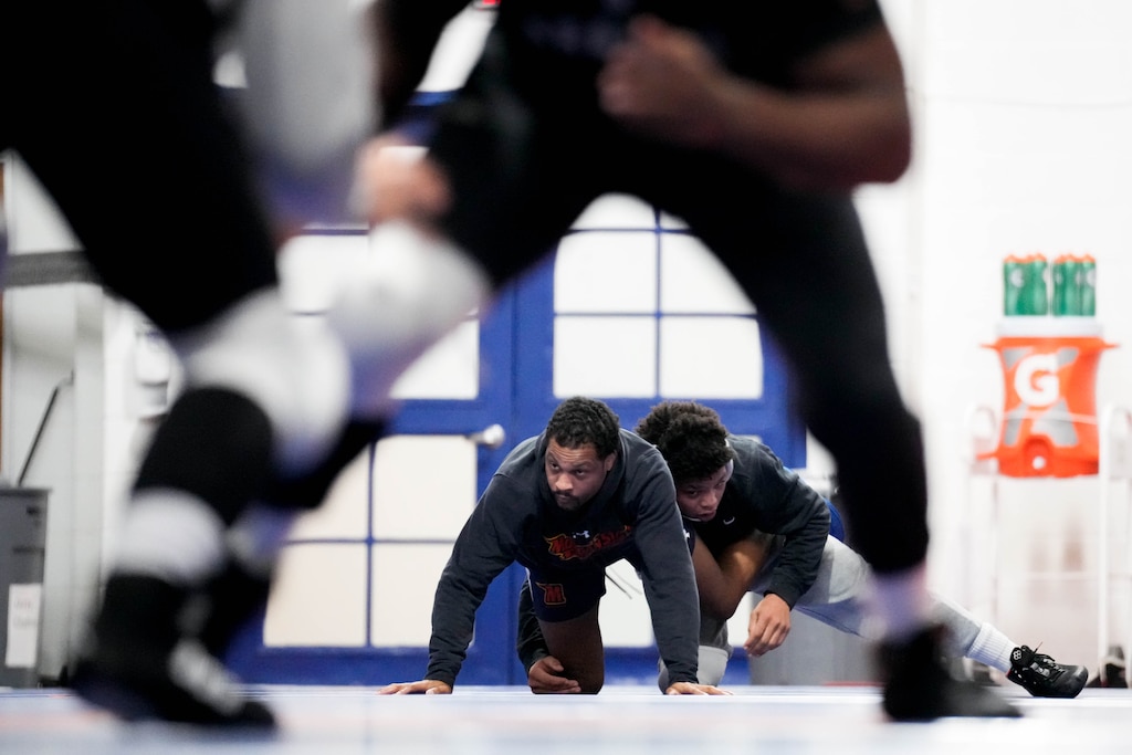 Yannis Charles, right, takes down assistant coach Alonzo Allen as they spars during wrestling practice at Hill Field House on Morgan State University’s campus in Baltimore, Md., on Monday, March 16, 2026.