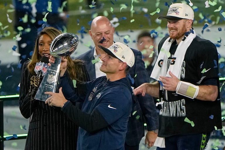 Seattle Seahawks head coach Mike Macdonald holds the trophy as quarterback Sam Darnold, right, and others look on after the team's win in the NFL Super Bowl 60 football game against the New England Patriots, Sunday, Feb. 8, 2026, in Santa Clara, Calif.