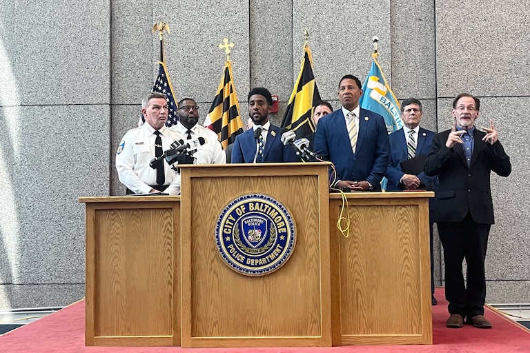 THURSDAY, JUNE 25, 2026 - Baltimore Mayor Brandon Scott is flanked by Police Commissioner Richard Worley, left, and State’s Attorney Ivan Bates as they announce the takedown of a violent carjacking crew that terrorized the city over two months.