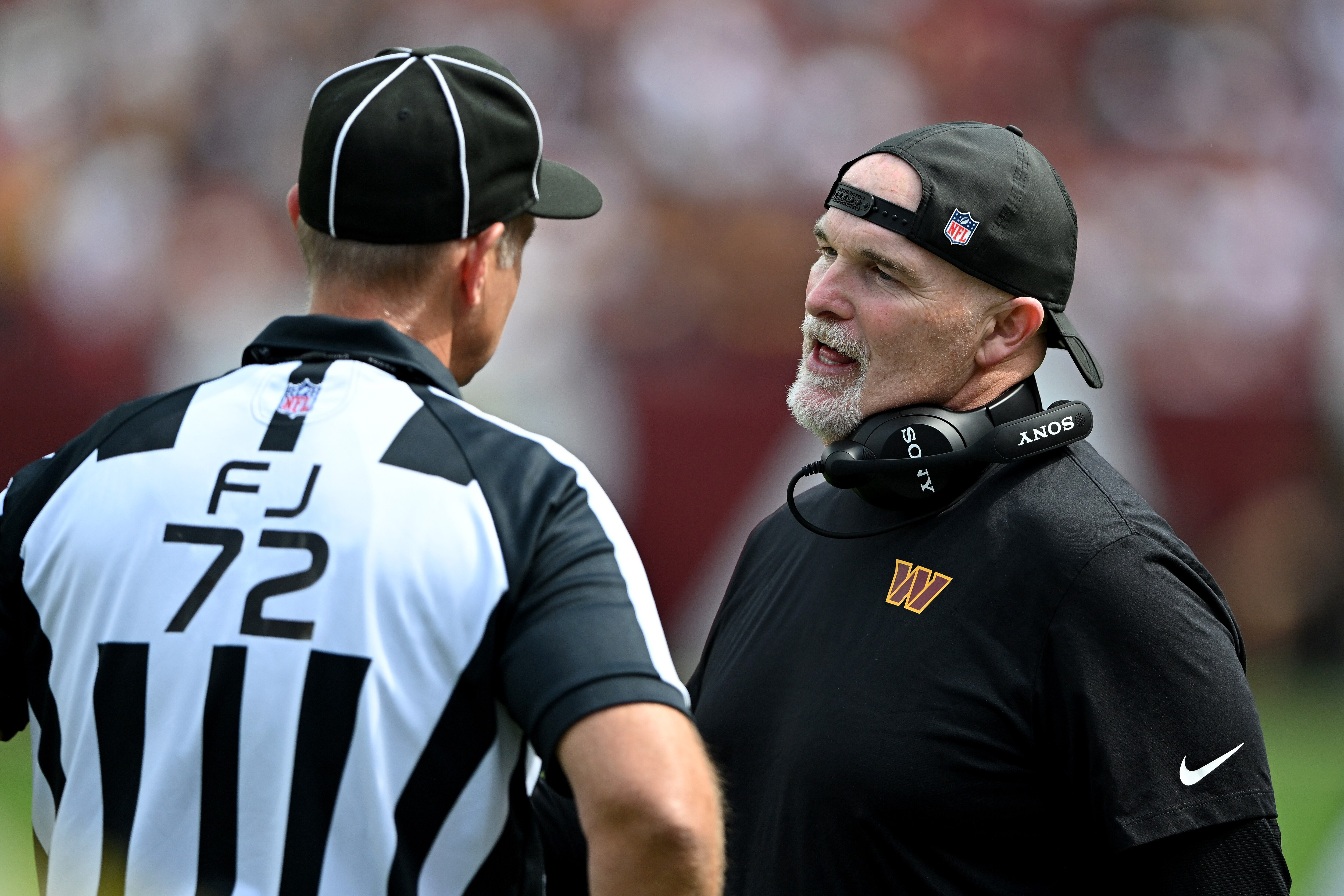 Head coach Dan Quinn of the Commanders speaks to an official during the second quarter Sunday in Landover.