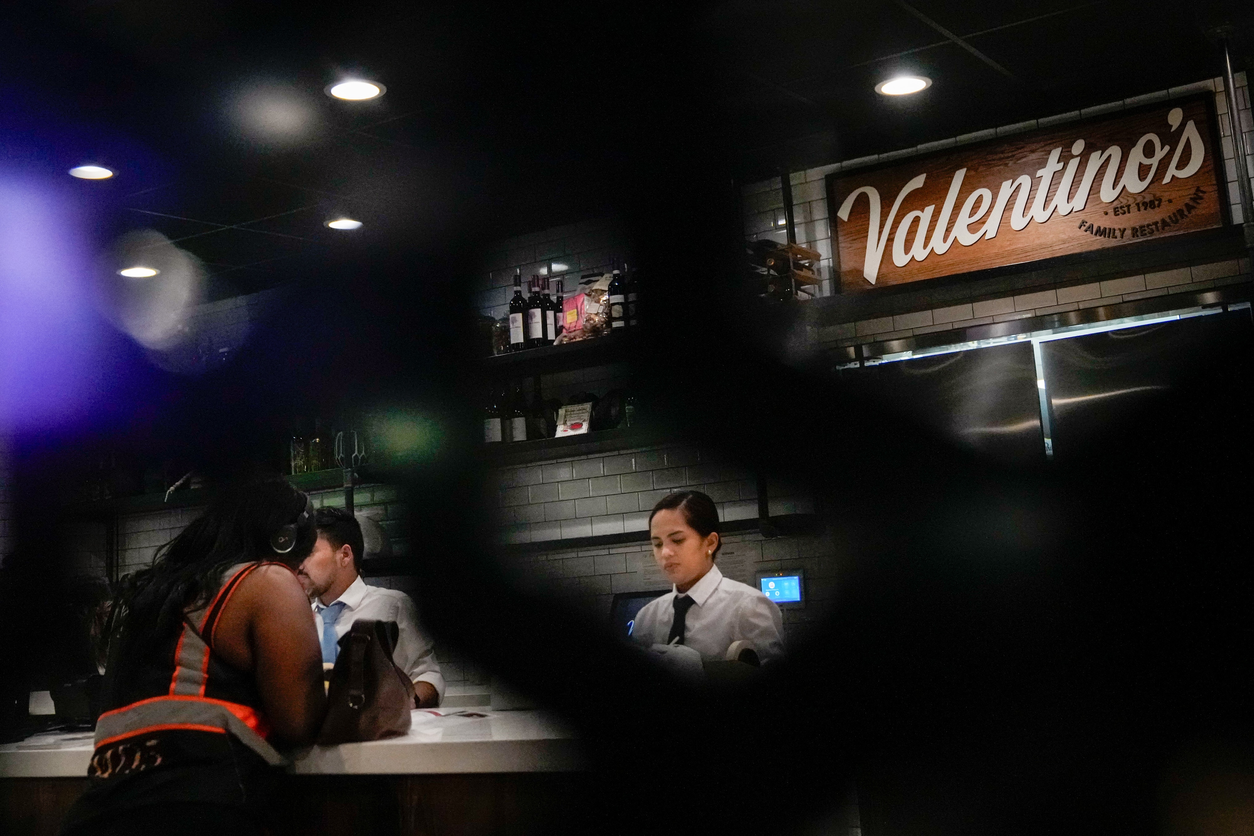 Staff members get orders ready to serve inside Valentino’s in Baltimore.