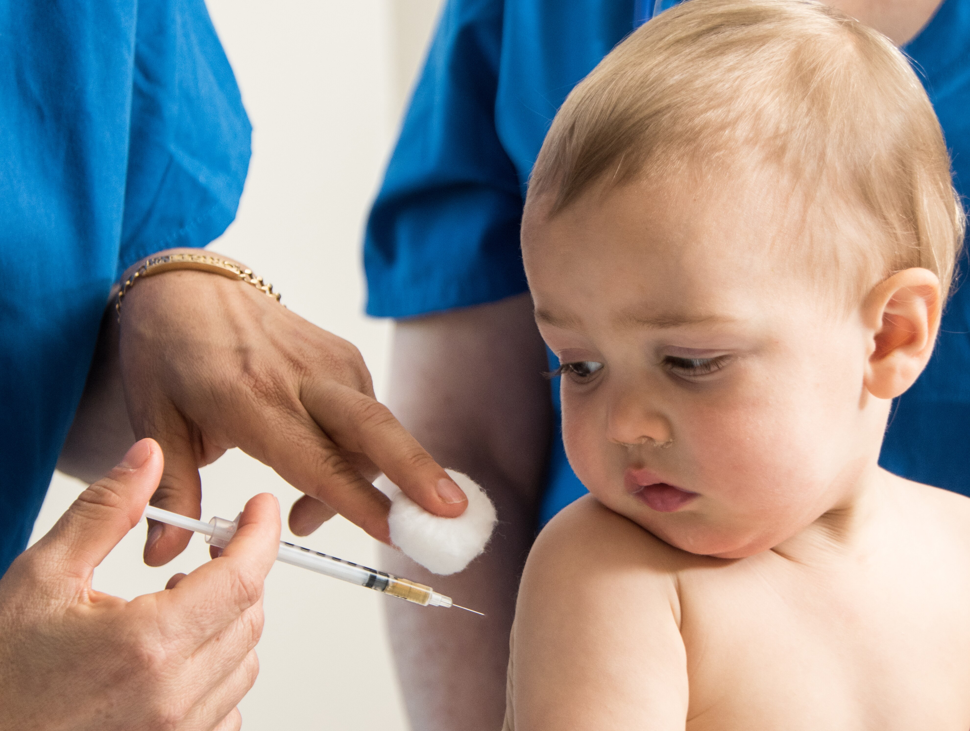 Caucasian baby boy being vaccinated by a female pediatrician