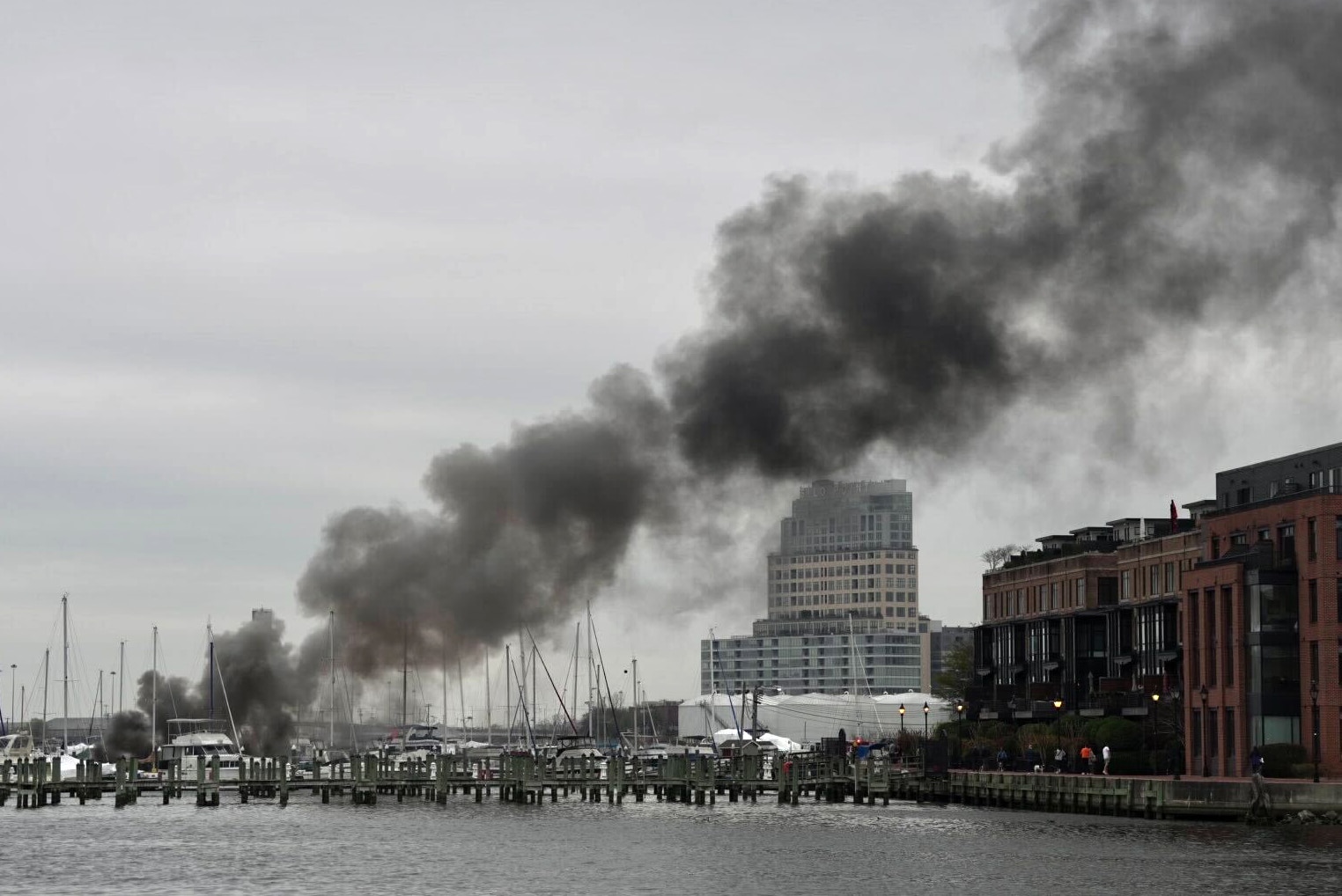 Smoke rises from a boat fire at Henderson’s Wharf Marina in Fells Point on Saturday.