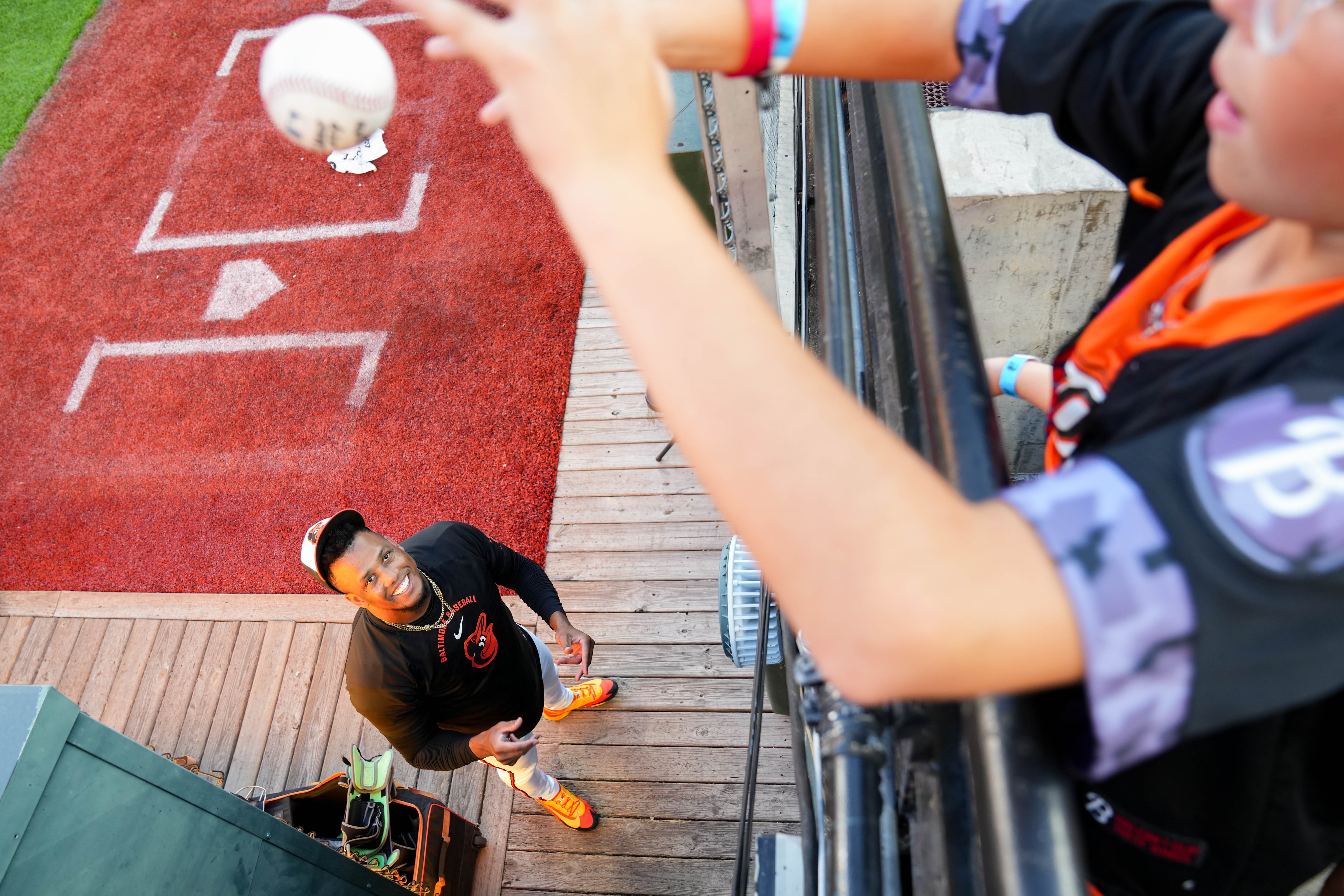 The Orioles’ bullpen pitchers like to keep things loose. Orioles relief pitcher Yennier Cano tosses a signed baseball to Caleb Guarnera, 11, from the bullpen ahead of a baseball game against the Cleveland Guardians last week. 