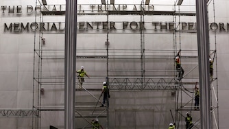 Workers construct scaffolding below the sign for the John F. Kennedy Center for the Performing Arts, Friday, June 12, 2026, in Washington. (AP Photo/Rahmat Gul)