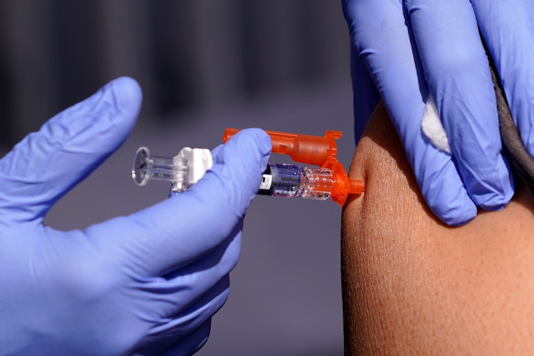 FILE - A patient is given a flu vaccine at the L.A. Care and Blue Shield of California Promise Health Plans' Community Resource Center where they were offering members and the public free flu and COVID-19 vaccines Friday, Oct. 28, 2022, in Lynwood, Calif. As Americans head into the late 2022 holiday season, a rapidly intensifying flu season is straining hospitals already overburdened with patients sick from other respiratory infections.