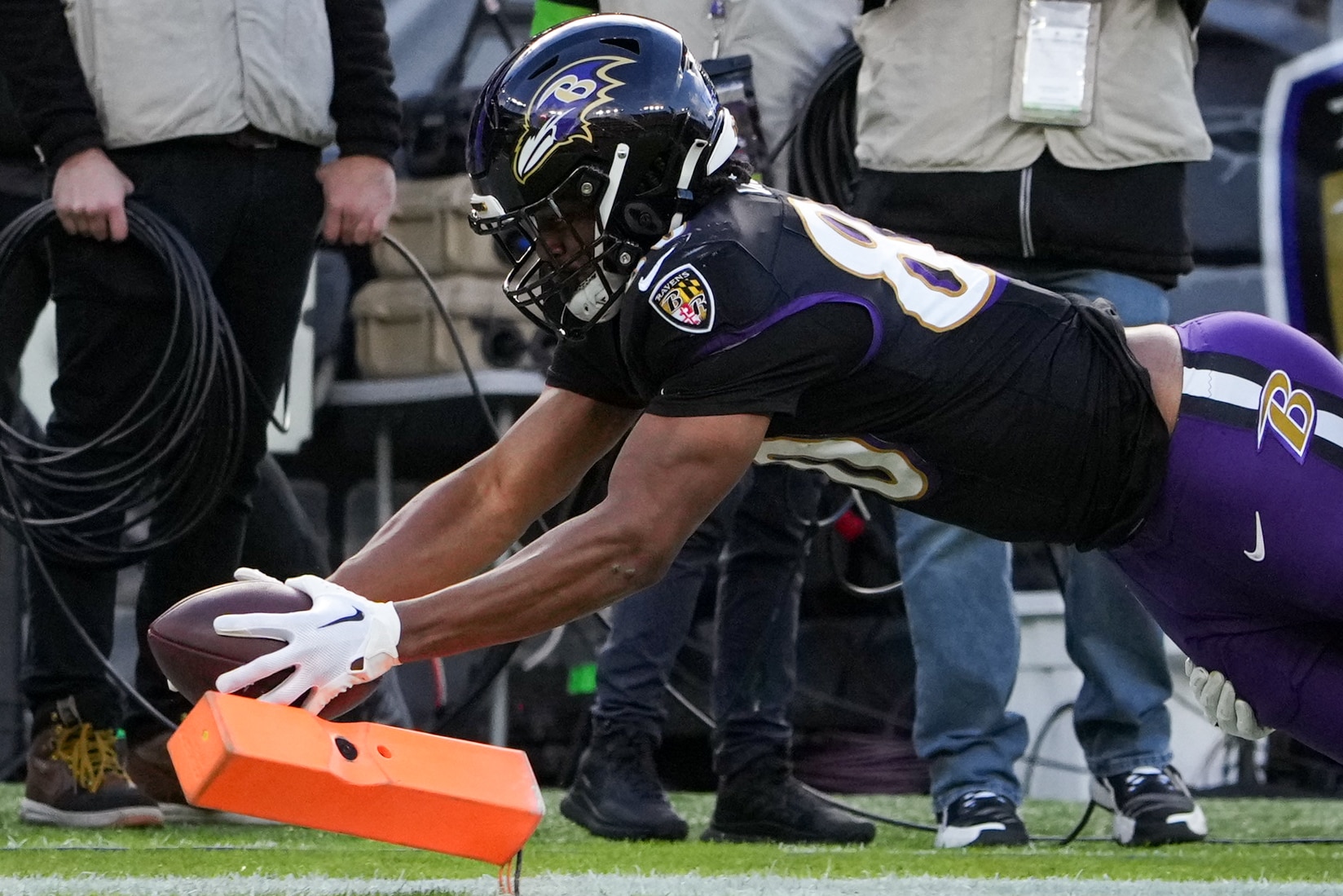 Baltimore Ravens tight end Isaiah Likely (80) extends his arms to score a touchdown against the Miami Dolphins at M&T Bank Stadium on Sunday, December 31, 2023. The Ravens won, 56-19, to secure the best record in the AFC.