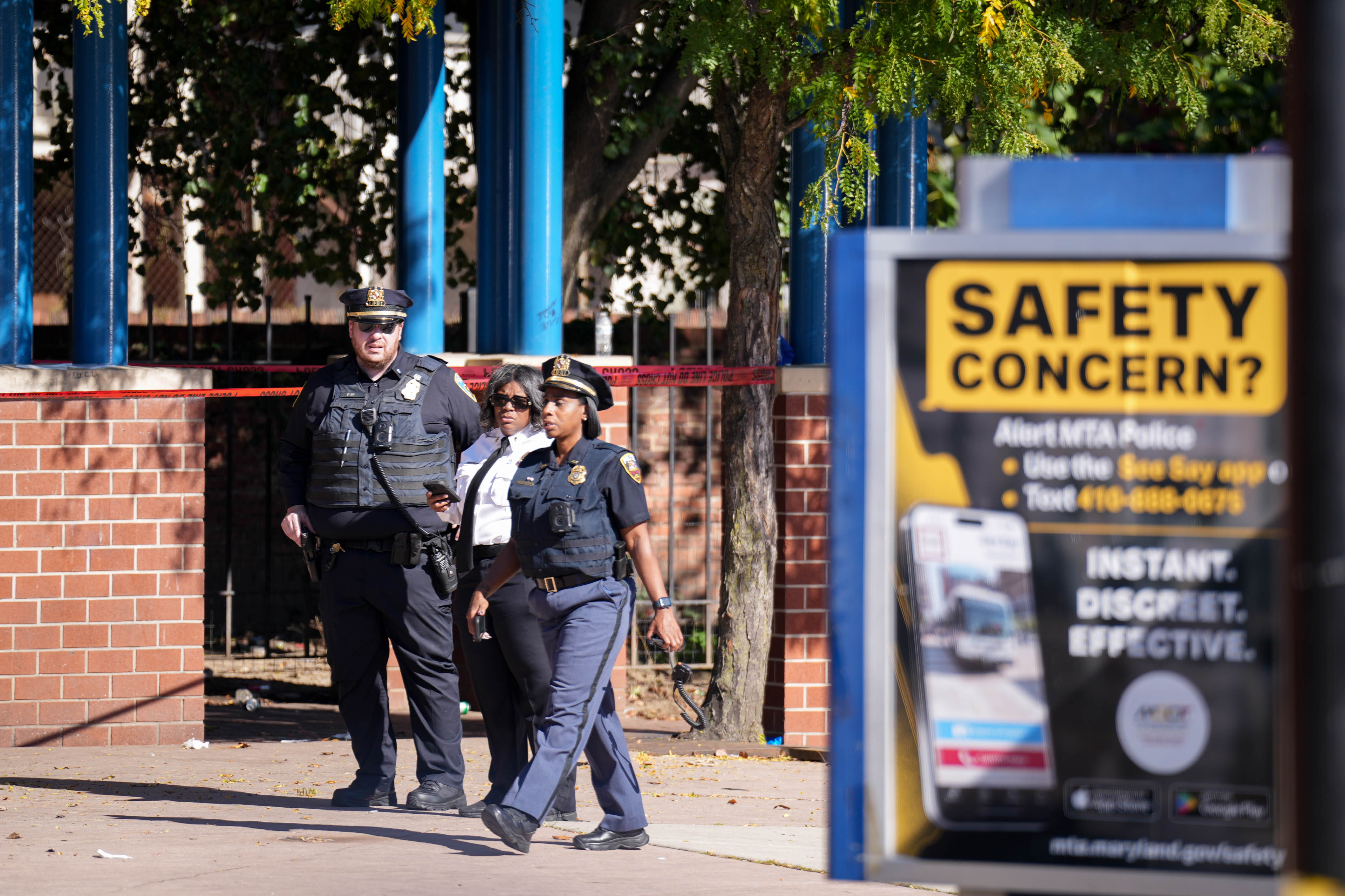 Baltimore Police officers examine the crime scene at the Penn-North metro station in Baltimore on Tuesday.