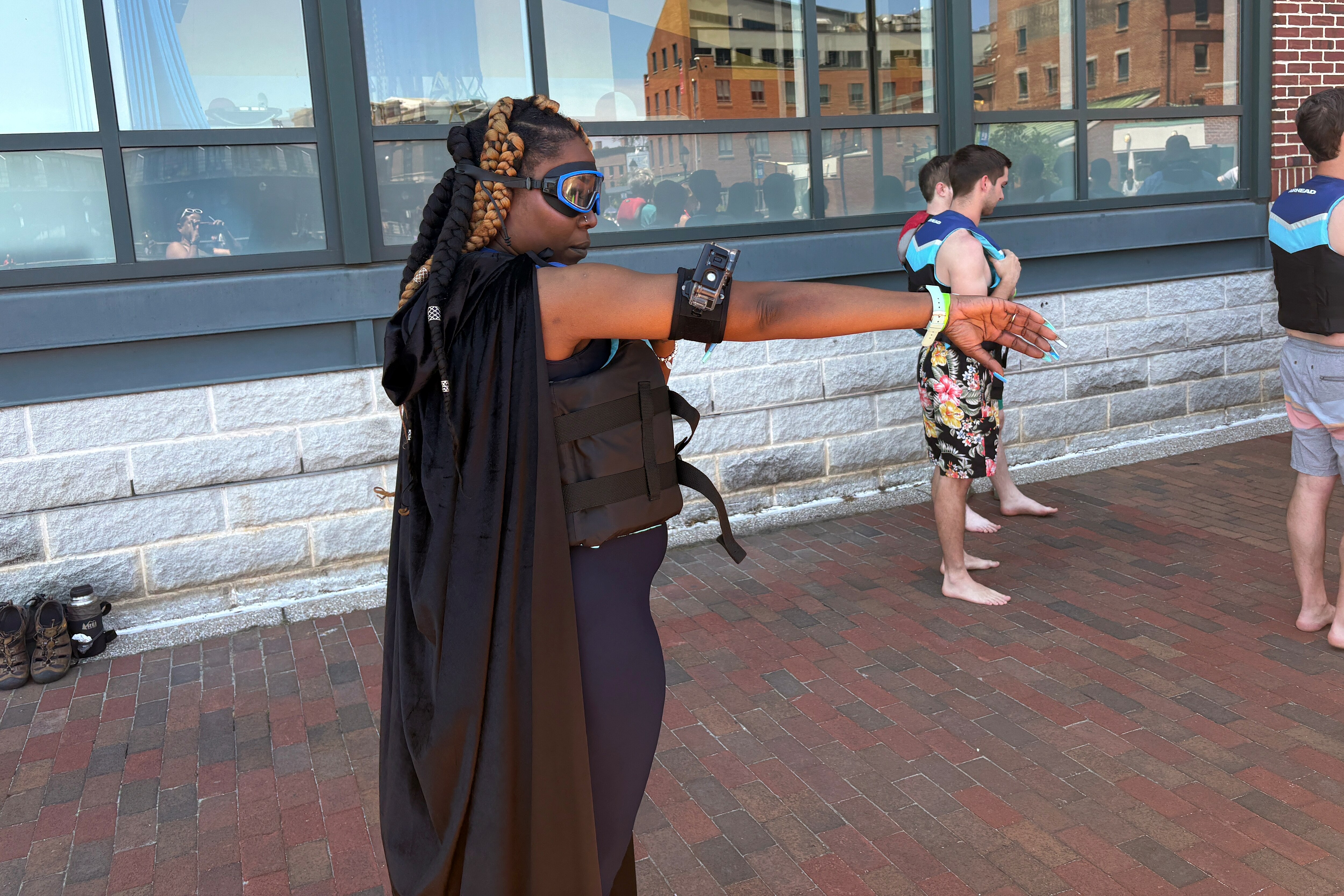 Tikia Ballard, a Woodlawn native and longtime science teacher, wore a google, waterproof camera and cape to prepare to jump off the pier at Fells Point's Bond Street Wharf as part of Waterfront Partnership's Harbor Splash on Sunday, May 31, 2026.