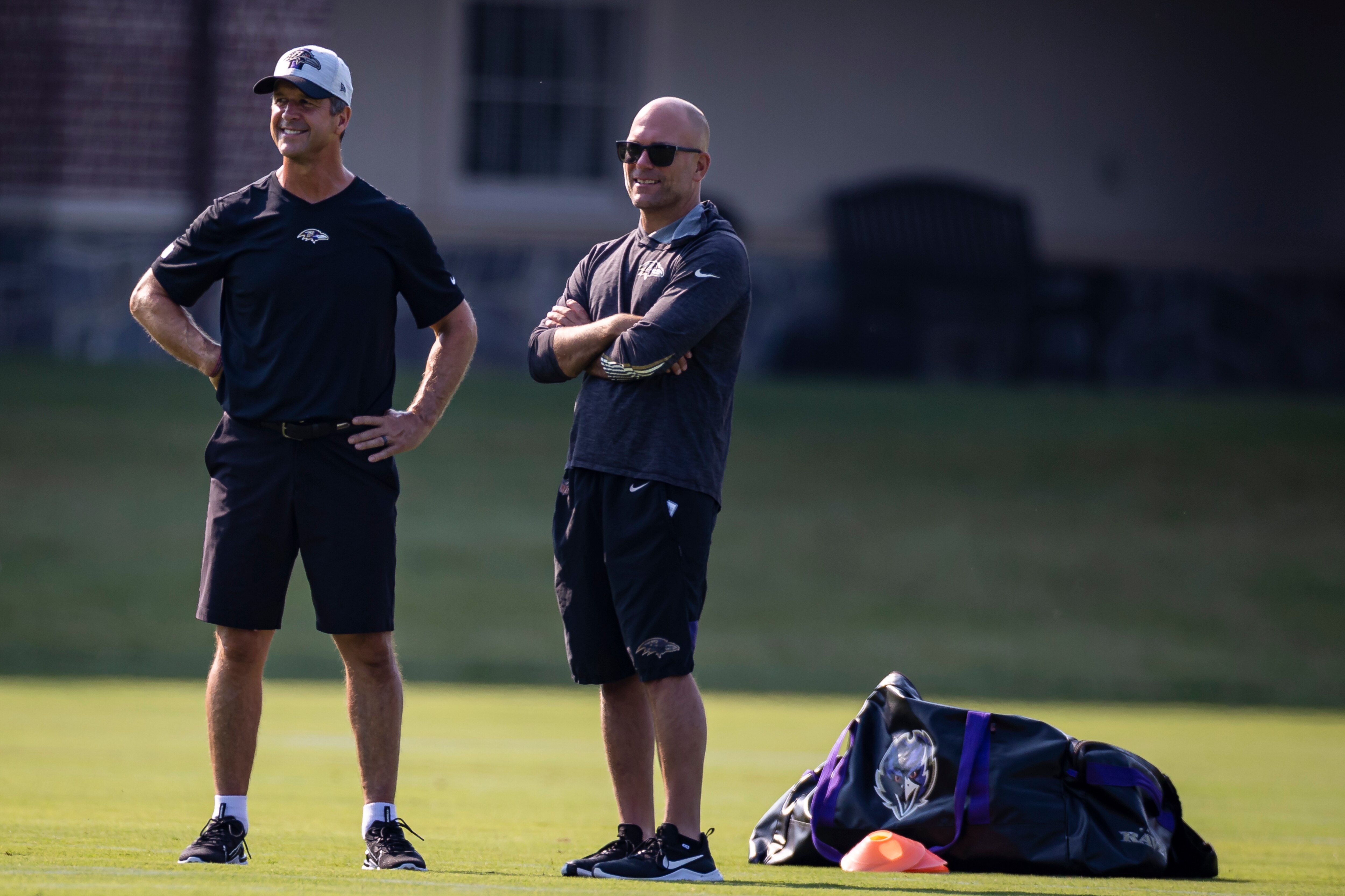 Head coach John Harbaugh and Executive Vice President and General Manager Eric DeCosta of the Baltimore Ravens watch play during training camp at Under Armour Performance Center Baltimore Ravens on July 28, 2021 in Owings Mills, Maryland.