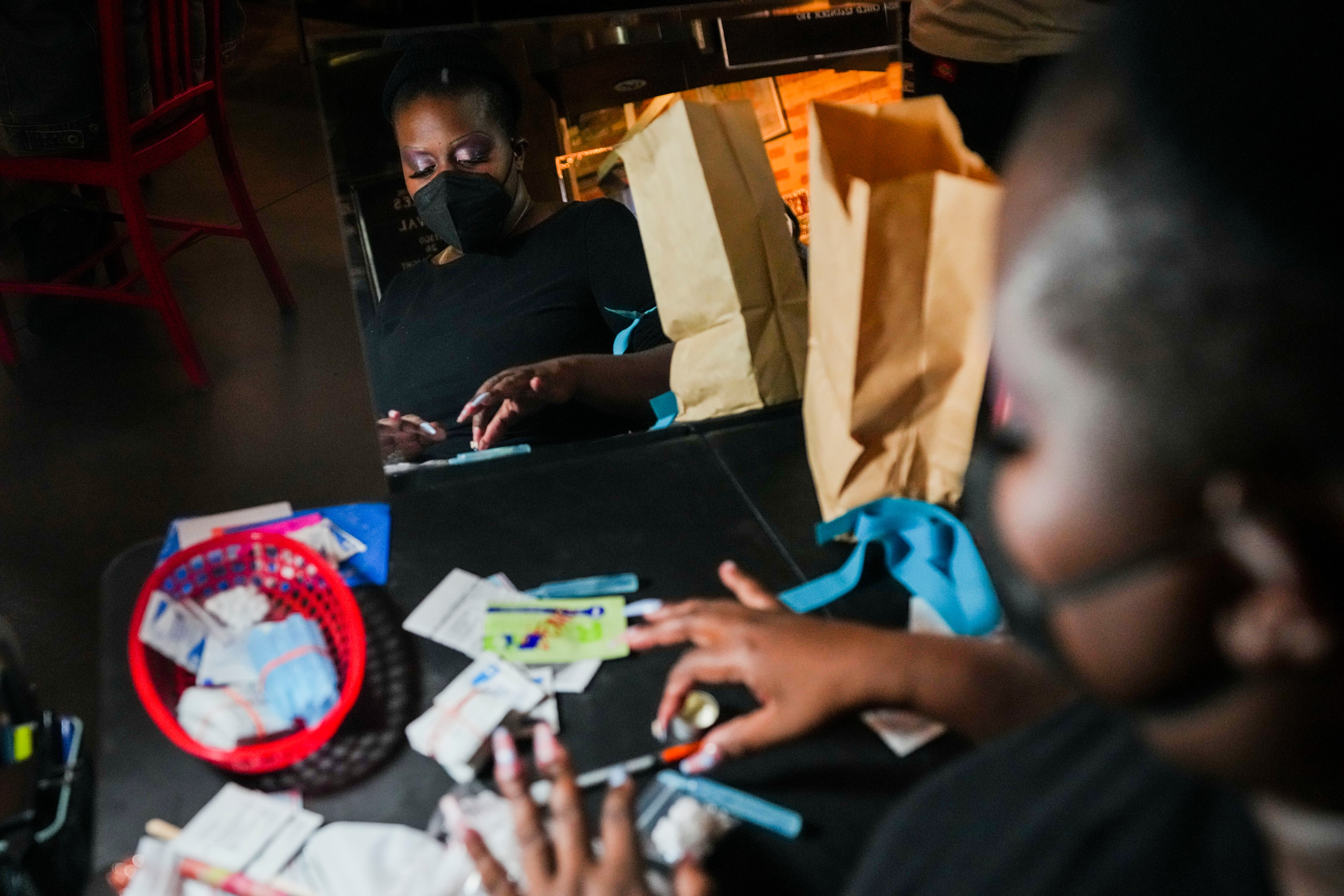 Candy Jovan demonstrates how an overdose prevention site would work at a mock setup at The Charles Theatre before the screening of a Canadian film about fentanyl on January 24, 2023.