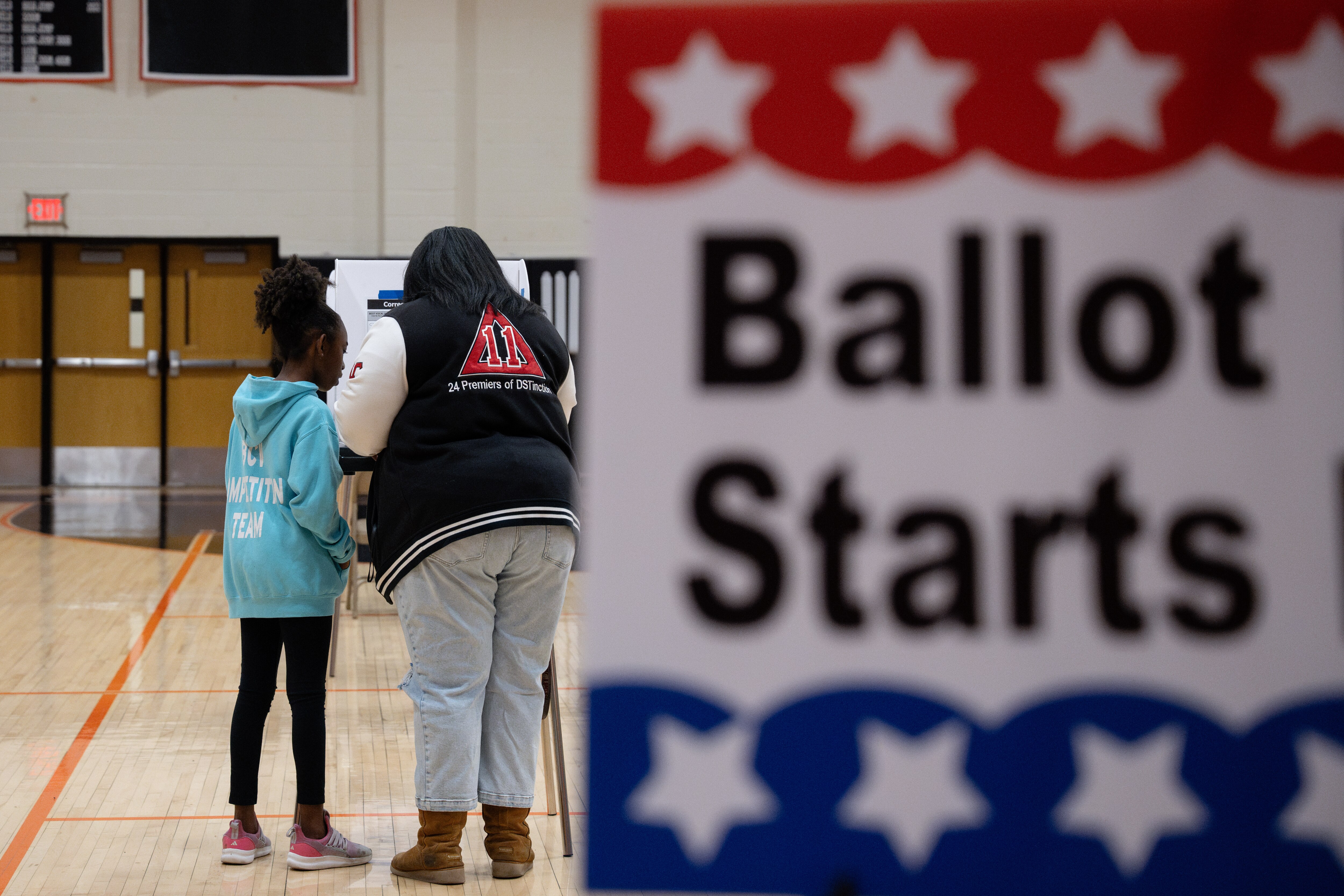A mother discusses her ballot with her daughter as she votes in Howard County's General Election as seen at Oakland Mills High School in Columbia, MD on November 5th, 2024.