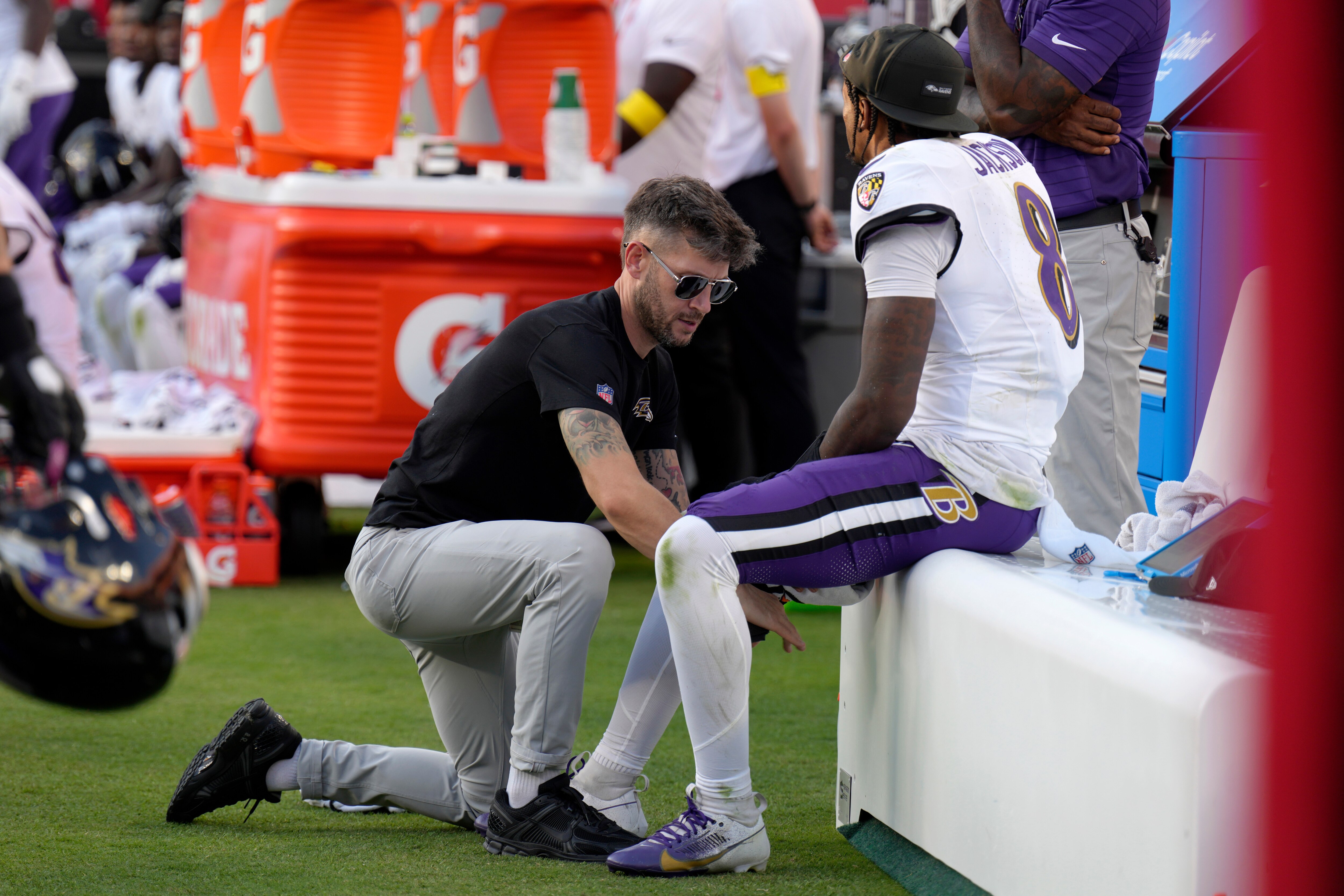 Ravens quarterback Lamar Jackson sits on the bench as his leg is worked on during the second half of the game at Kansas City on Sunday.