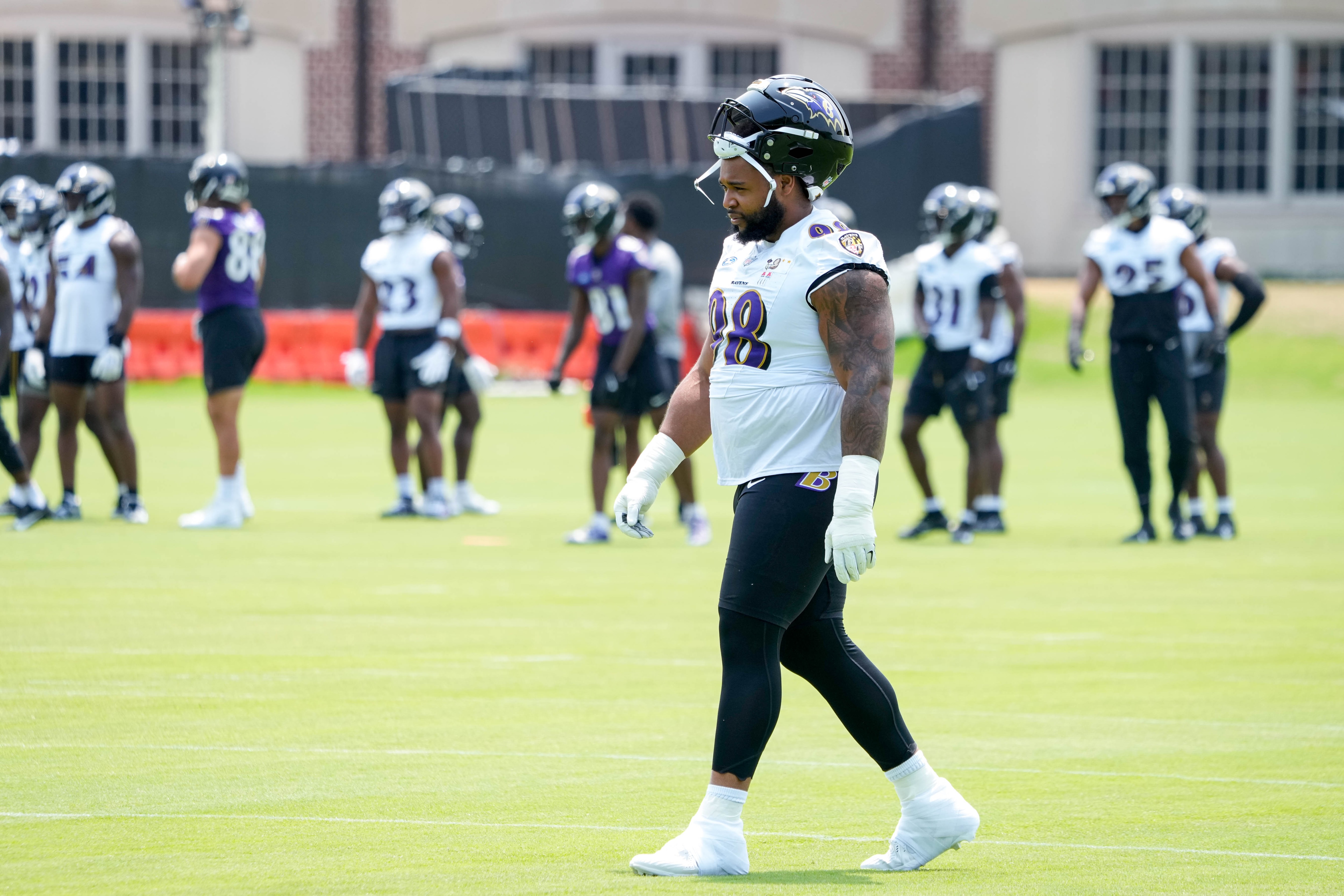 Ravens defensive tackle Travis Jones (98) walks to join his teammates during organized team activities in June.