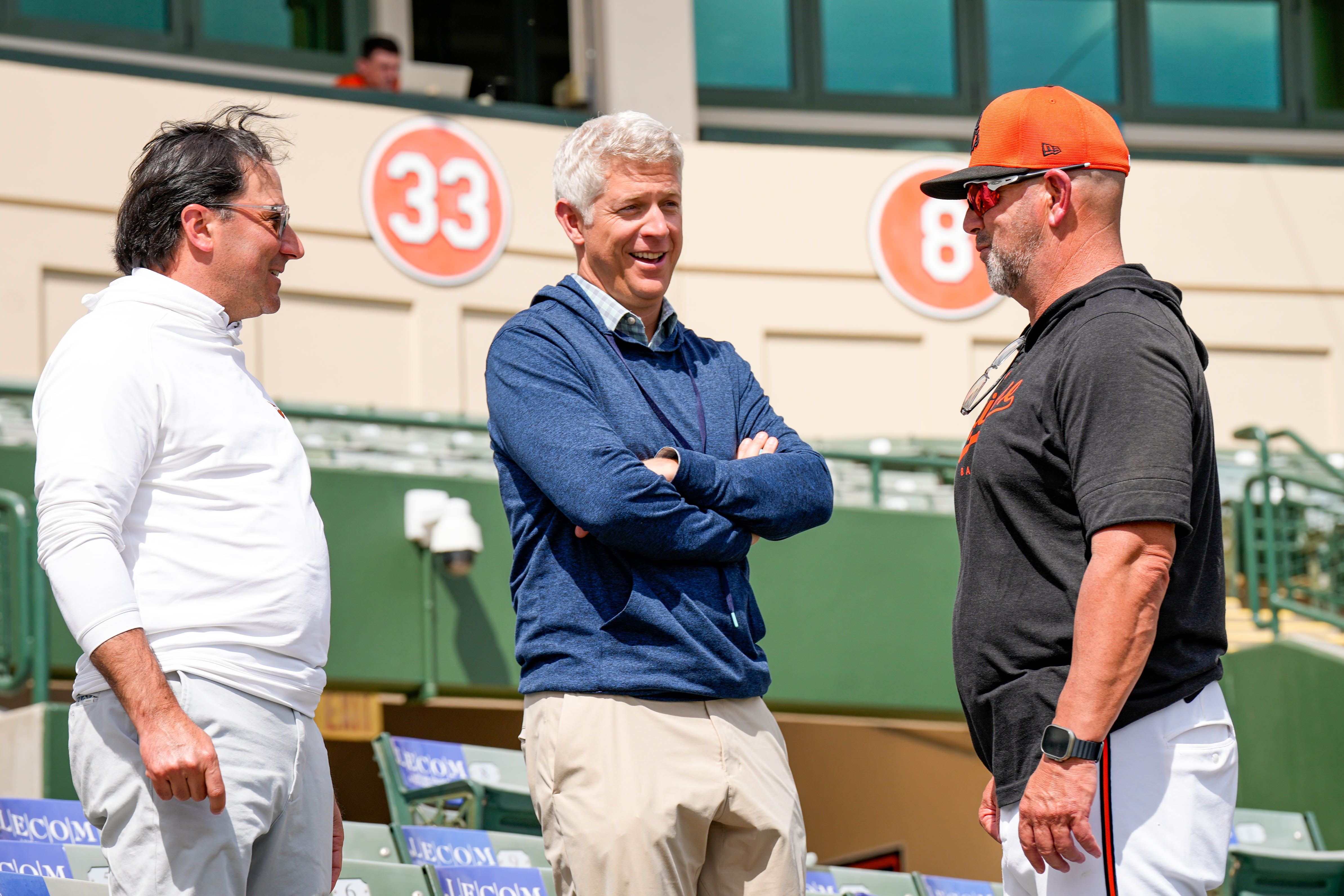 Orioles co-owner Michael J. Arougheti, left, talks with general manager Mike Elias, middle, and manager Brandon Hyde during spring training.