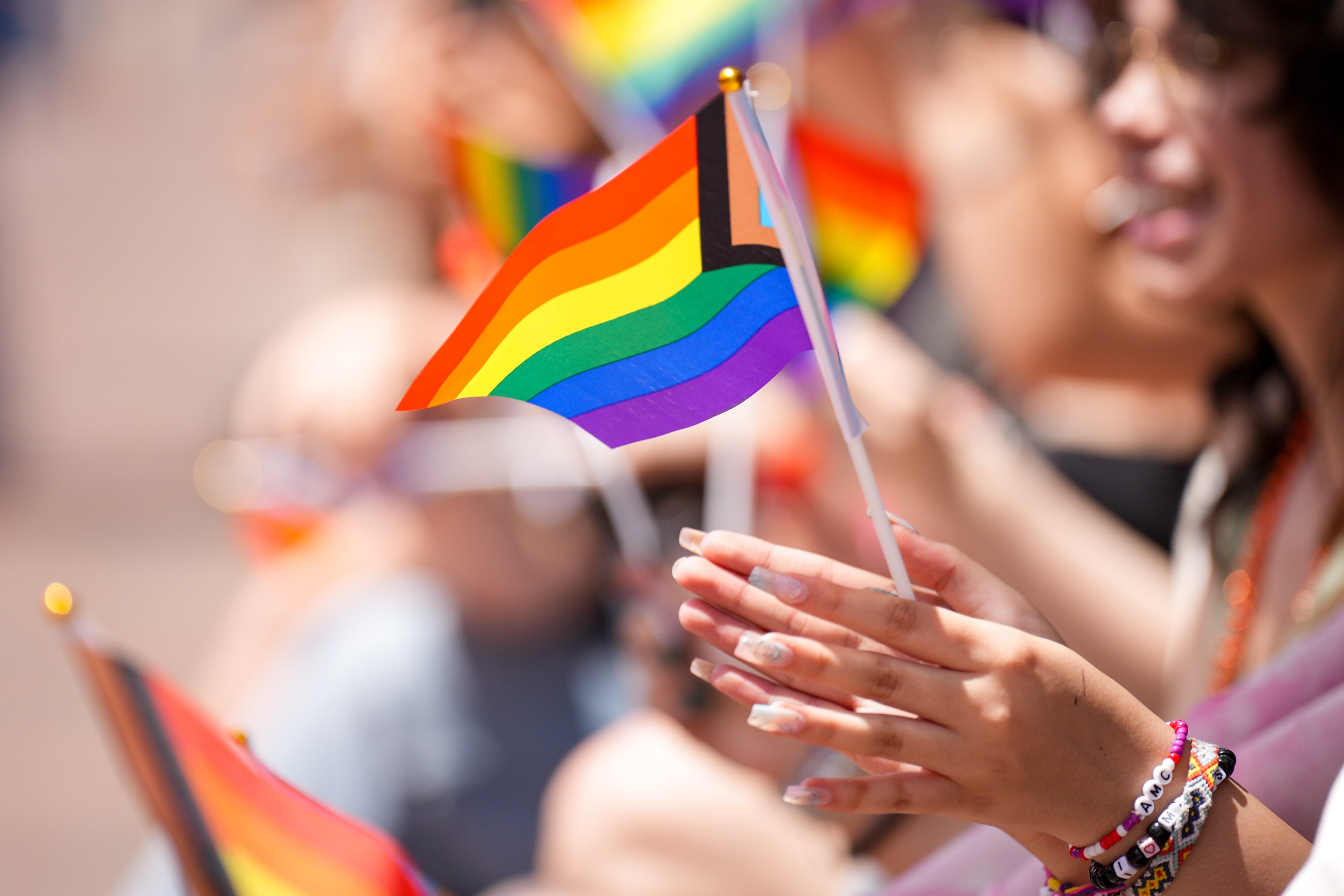 People wave rainbow flags on West Street during the Annapolis Pride Parade and Festival on June 1, 2024.