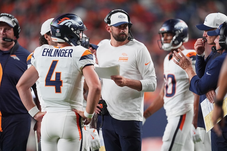 Denver Broncos quarterback Sam Ehlinger (4) confers with quarterbacks coach Davis Webb in the second half of a preseason game game against the Arizona Cardinals on Aug. 16, 2025.