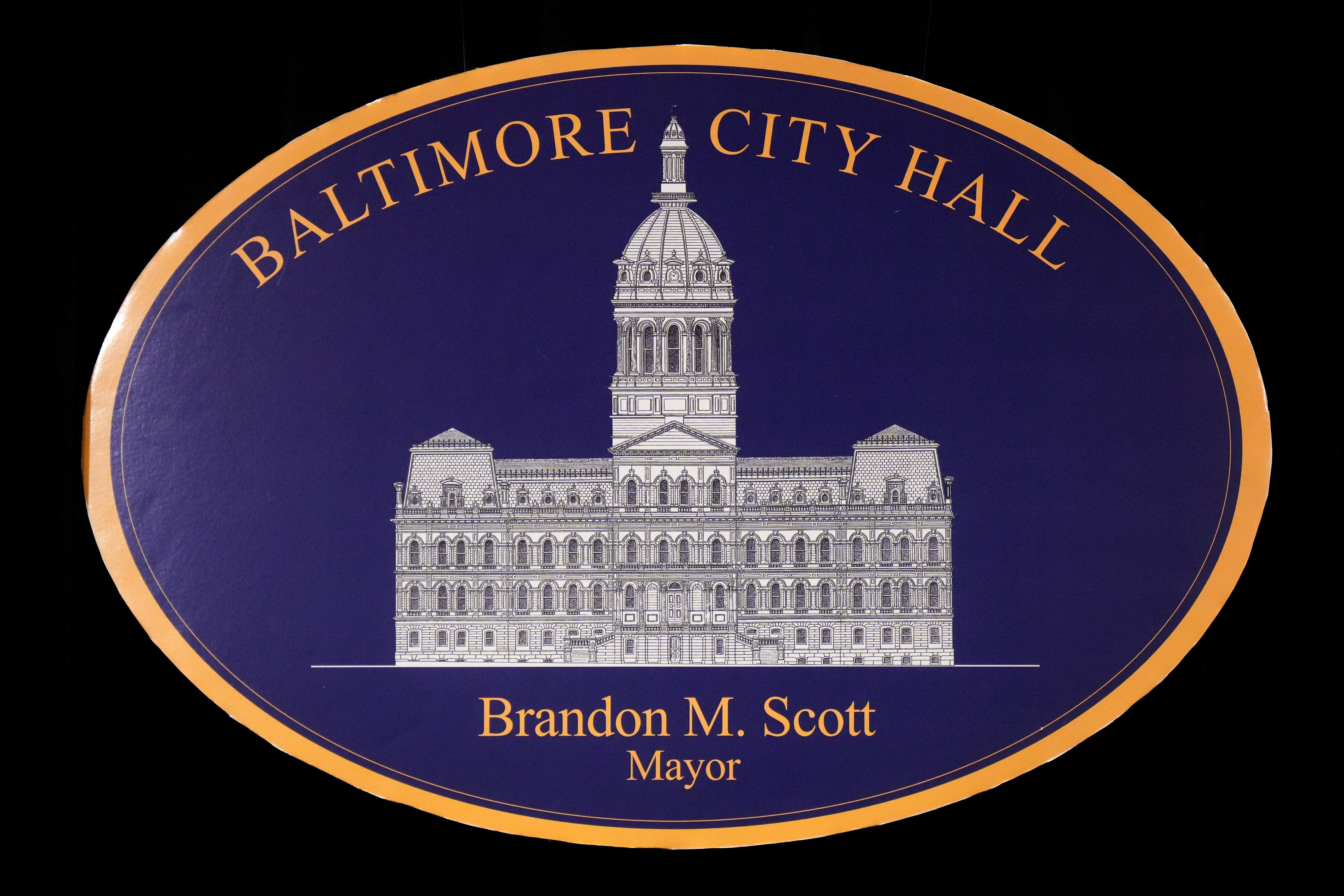 The Baltimore City Hall logo with Mayor Brandon Scott’s name beneath it is seen after a press conference inside Baltimore City Hall on Friday, June 23, 2023.