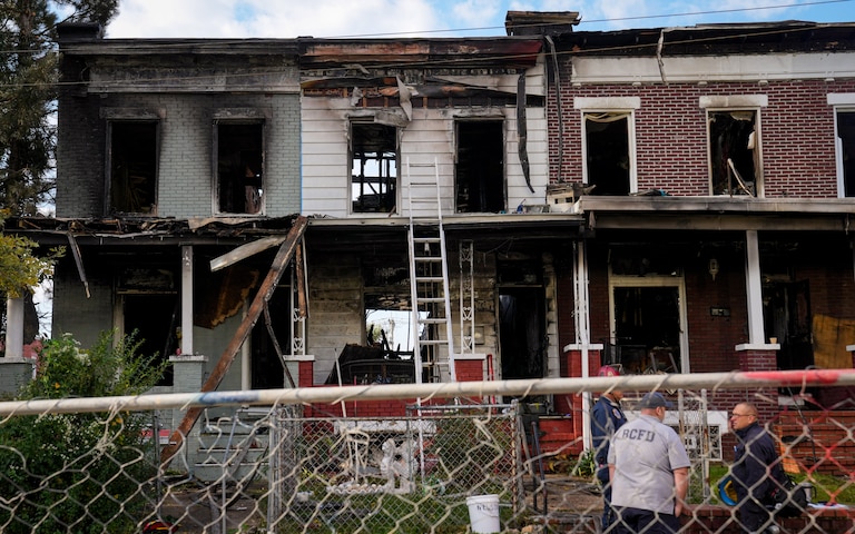Baltimore City Fire Department and ATF officials examine multiple burned rowhomes in the 5200 block of Linden Heights Ave. on Friday, October 20, 2023. The fatal fire the previous night took the lives of two firefighters and injured multiple others.