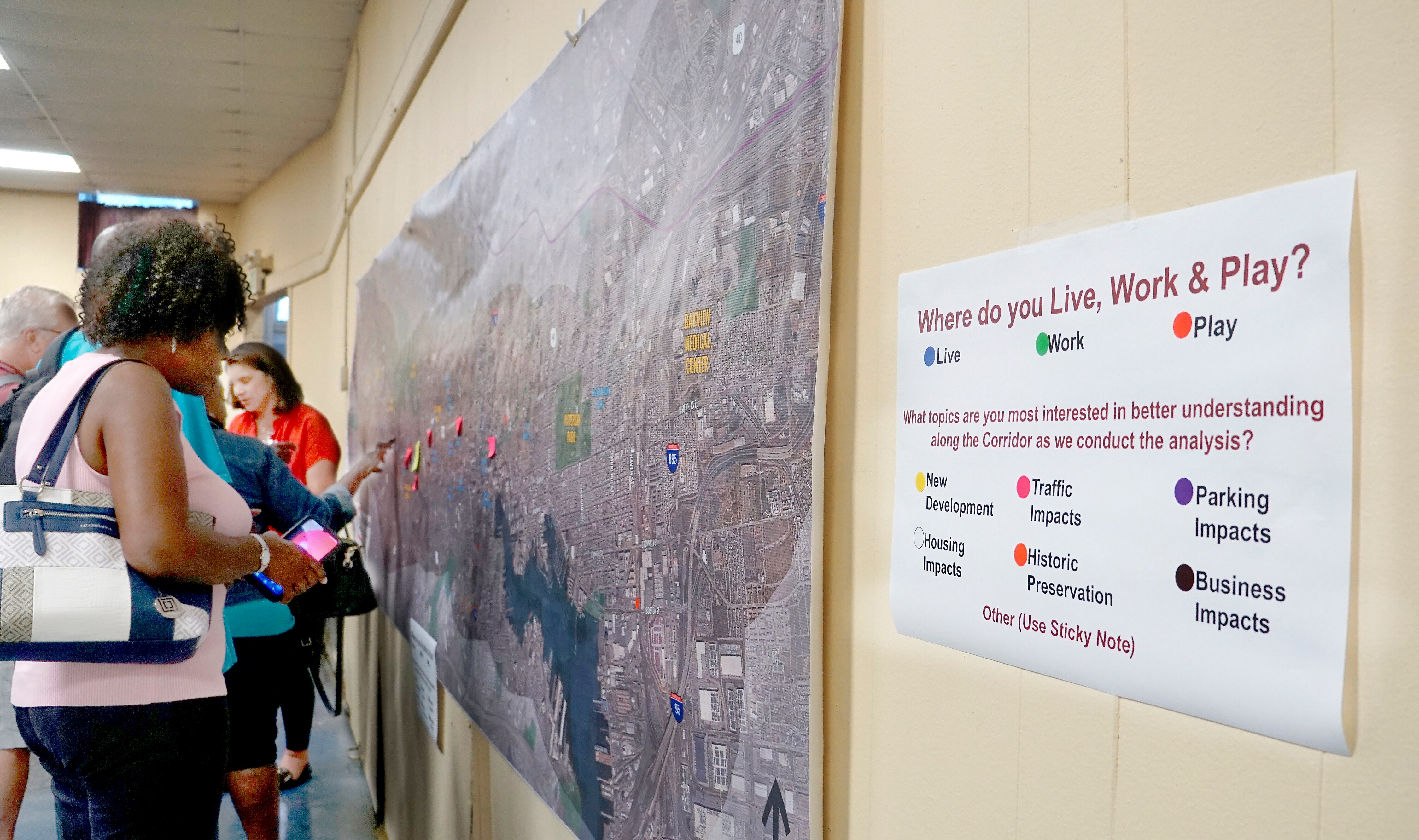 Community members place stickers on a map of the proposed Red Line corridor on July 26, 2023, at St. Bernardine Church in West Baltimore, providing information that MTA hopes will inform plans for the Red Line.