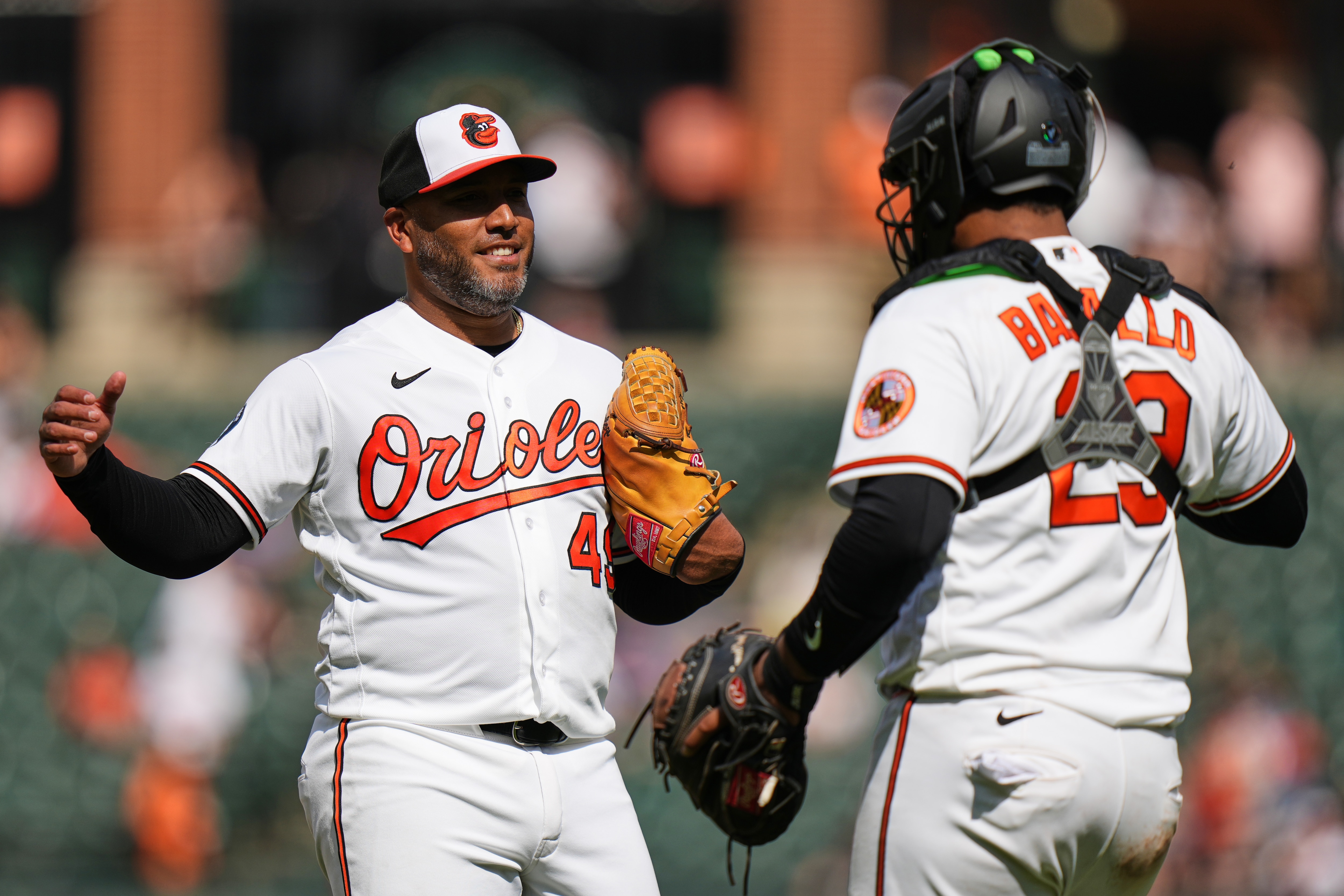 Orioles pitcher Albert Suarez, left, and catcher Samuel Basallo, right, celebrate the team's victory over the Texas Rangers.