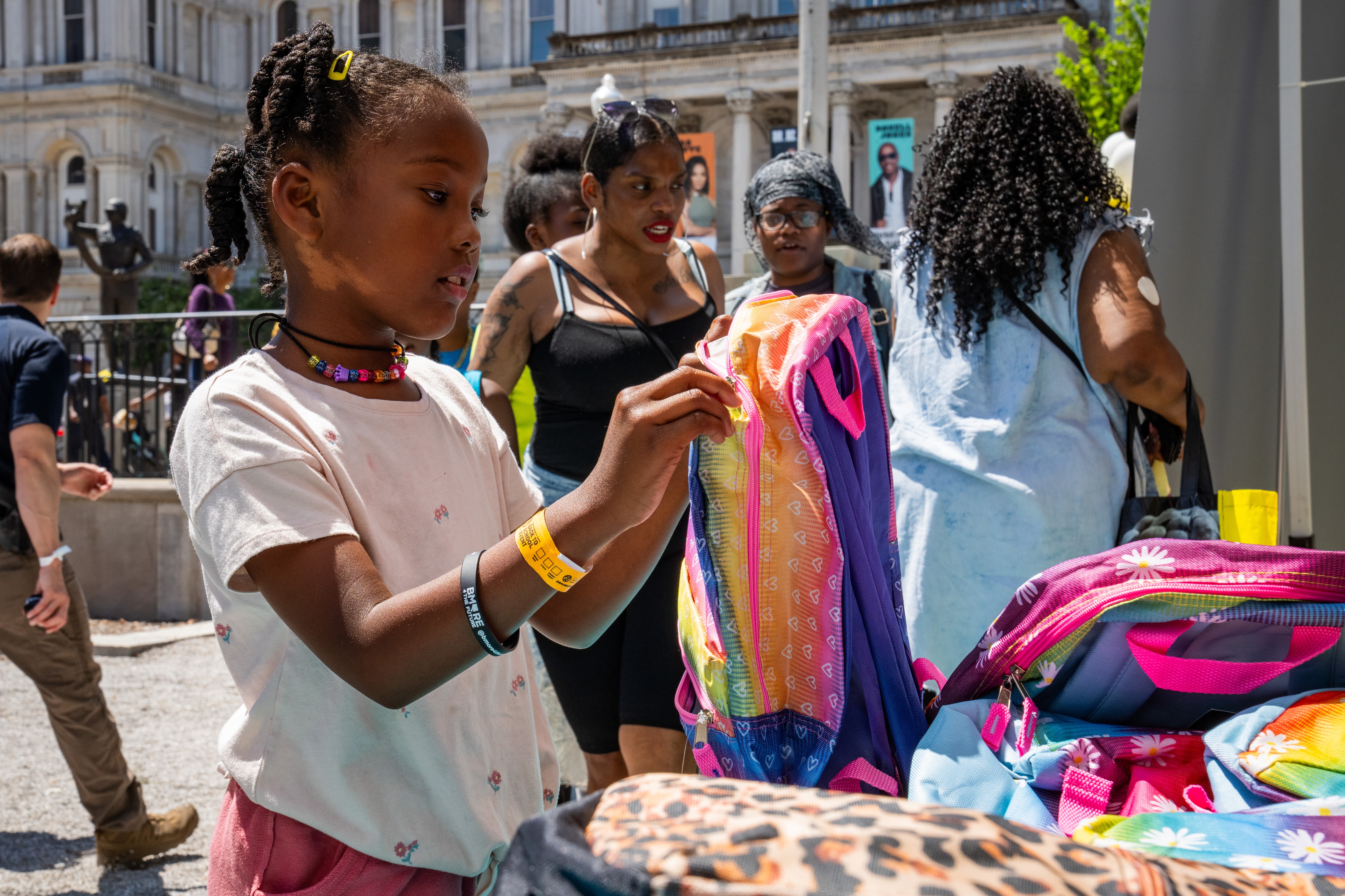 Assata, 7, inspects her new rainbow backpack.