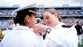 Midshipman Jenna Jeletic, right, puts the shoulder boards on her friend, newly commissioned naval officer Arianna Longo, following the U.S. Naval Academy Class of 2025’s graduation ceremony at the Navy-Marine Corps Memorial Stadium in Annapolis, Md. on Friday, May 23, 2025.