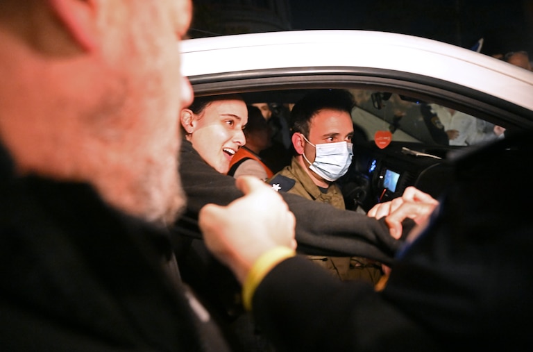 RAMAT GAN, ISRAEL - JANUARY 19: Friends reach out to British-Israeli hostage Emily Damari as she arrives at Sheba Medical Center, also known as Tel HaShomer Hospital, where hostages are arriving after the first phase of a ceasefire agreement began between Israel and Hamas on January 19, 2025 in Ramat Gan, Israel. A total of 33 Israeli hostages, taken captive by Hamas and allied groups on Oct. 7, 2023, were to be released in the first phase of the ceasefire, in exchange for 1,890 Palestinian prisoners. Of the 251 hostages taken on Oct. 7, 94 are still held in Gaza, with 60 assumed to be living and 34 dead.