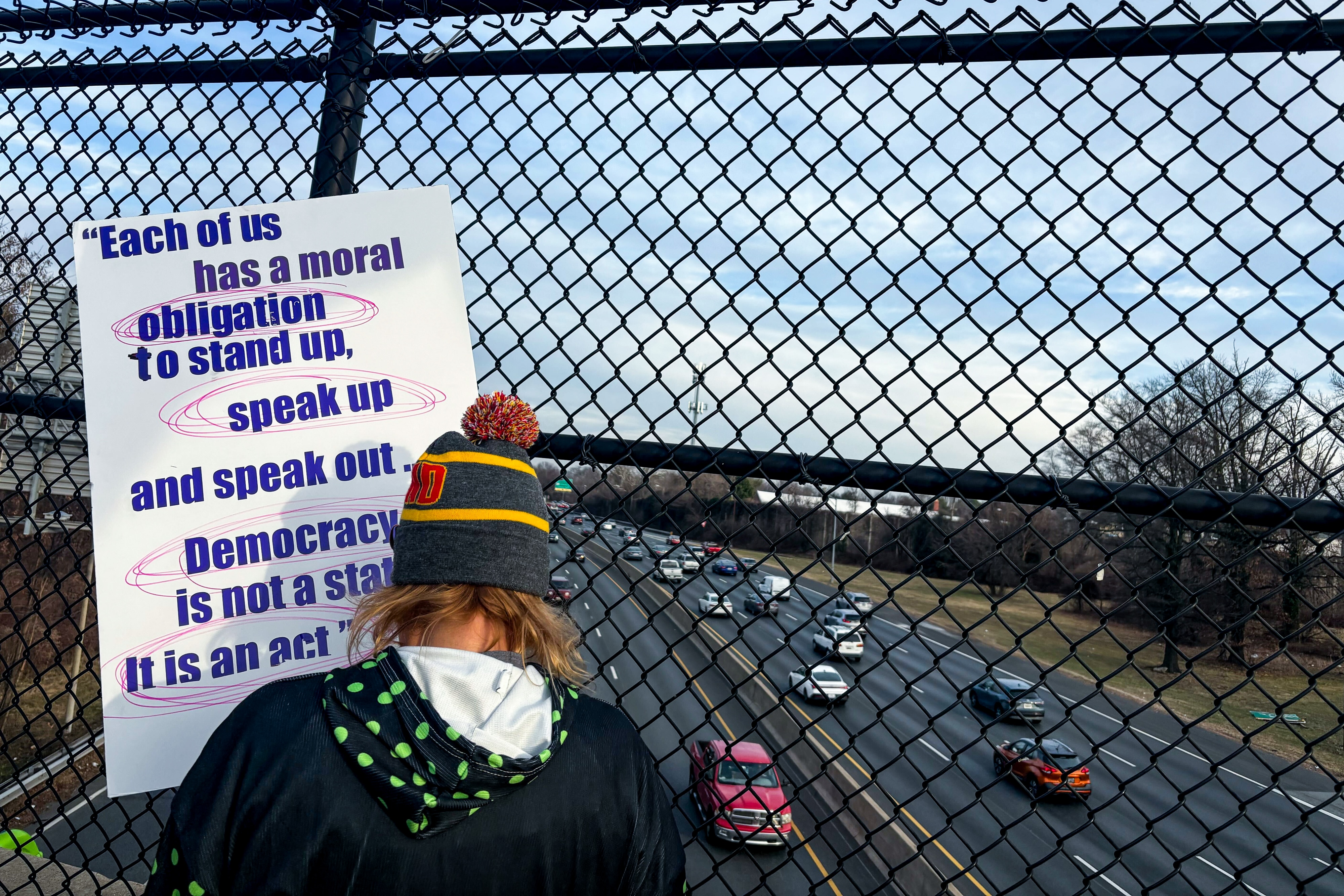 Protesters gather with signs at the Colesville Road overpass at I-495 in Silver Spring, the day after an ICE shooting in Minneapolis, Minn.