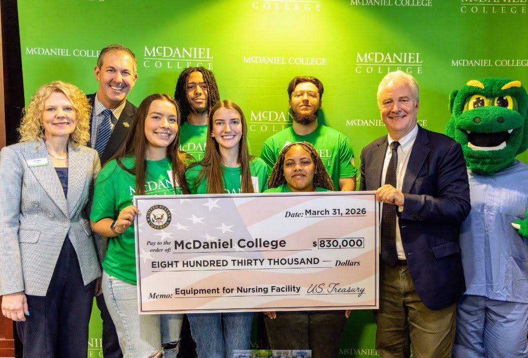 U.S. Sen. Chris Van Hollen and U.S. Rep. Johnny Olszewski present a fake check for $830,000 to help fund a new nursing education facility at McDaniel College in Westminster.