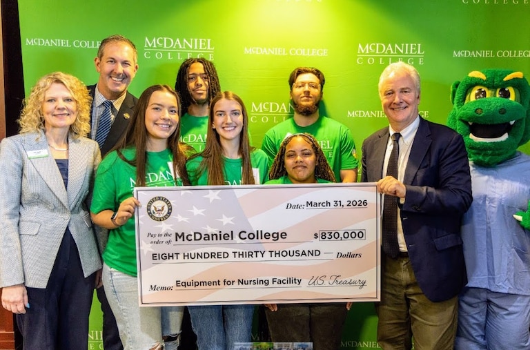 U.S. Sen. Chris Van Hollen and U.S. Rep. Johnny Olszewski present a fake check for $830,000 to help fund a new nursing education facility at McDaniel College in Westminster.