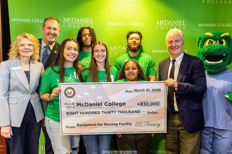 U.S. Sen. Chris Van Hollen and U.S. Rep. Johnny Olszewski present a fake check for $830,000 to help fund a new nursing education facility at McDaniel College in Westminster.