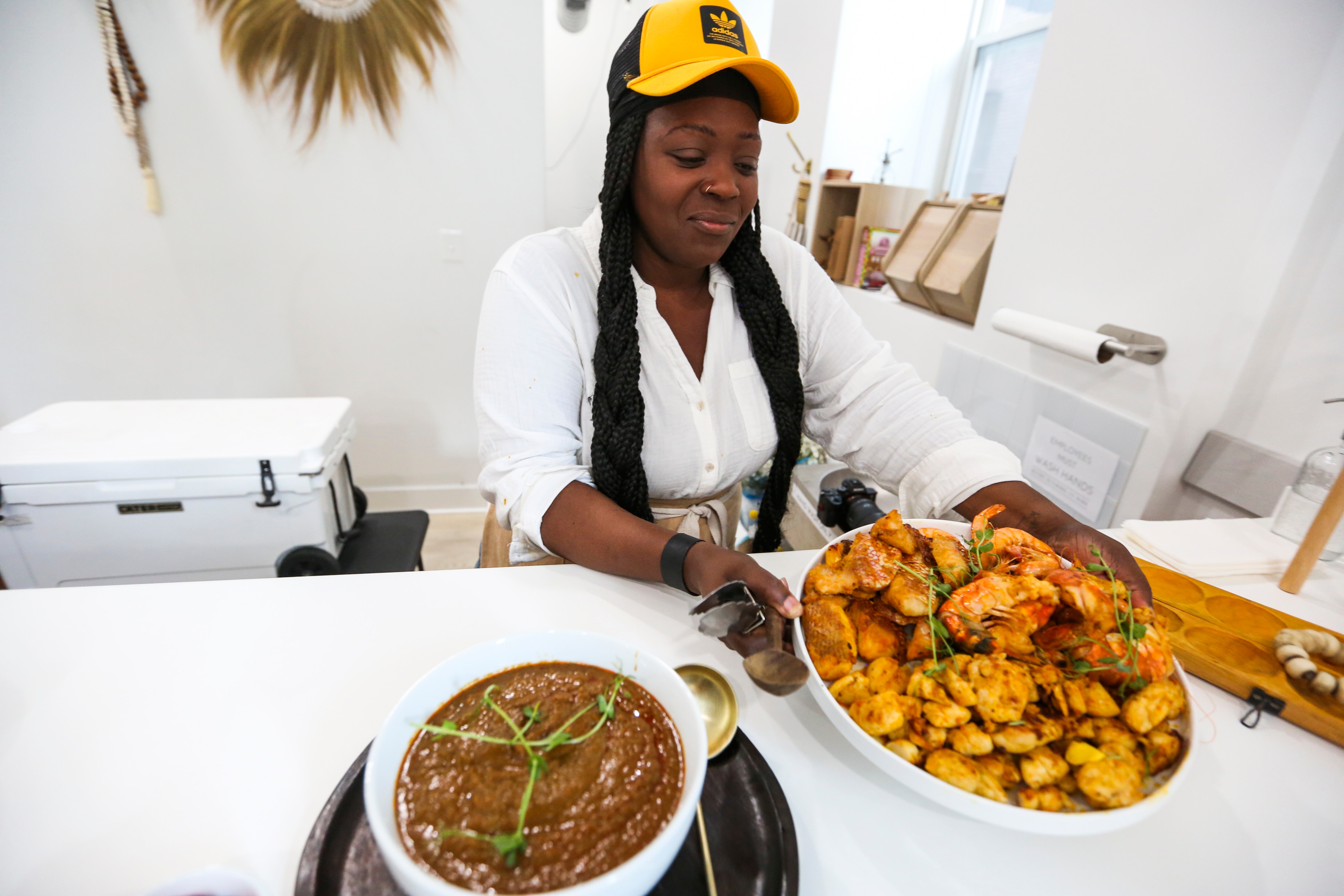 Carleen Goodridge prepped various Liberian dishes such as a salad with tomatos, cucumber, mango, papaya, and onion, palm butter stew, snapper, shrimp and chicken, mashed cassava, and par-boiled rice as a celebration of her culture and Liberia’s Independence Day on July 24, 2022.