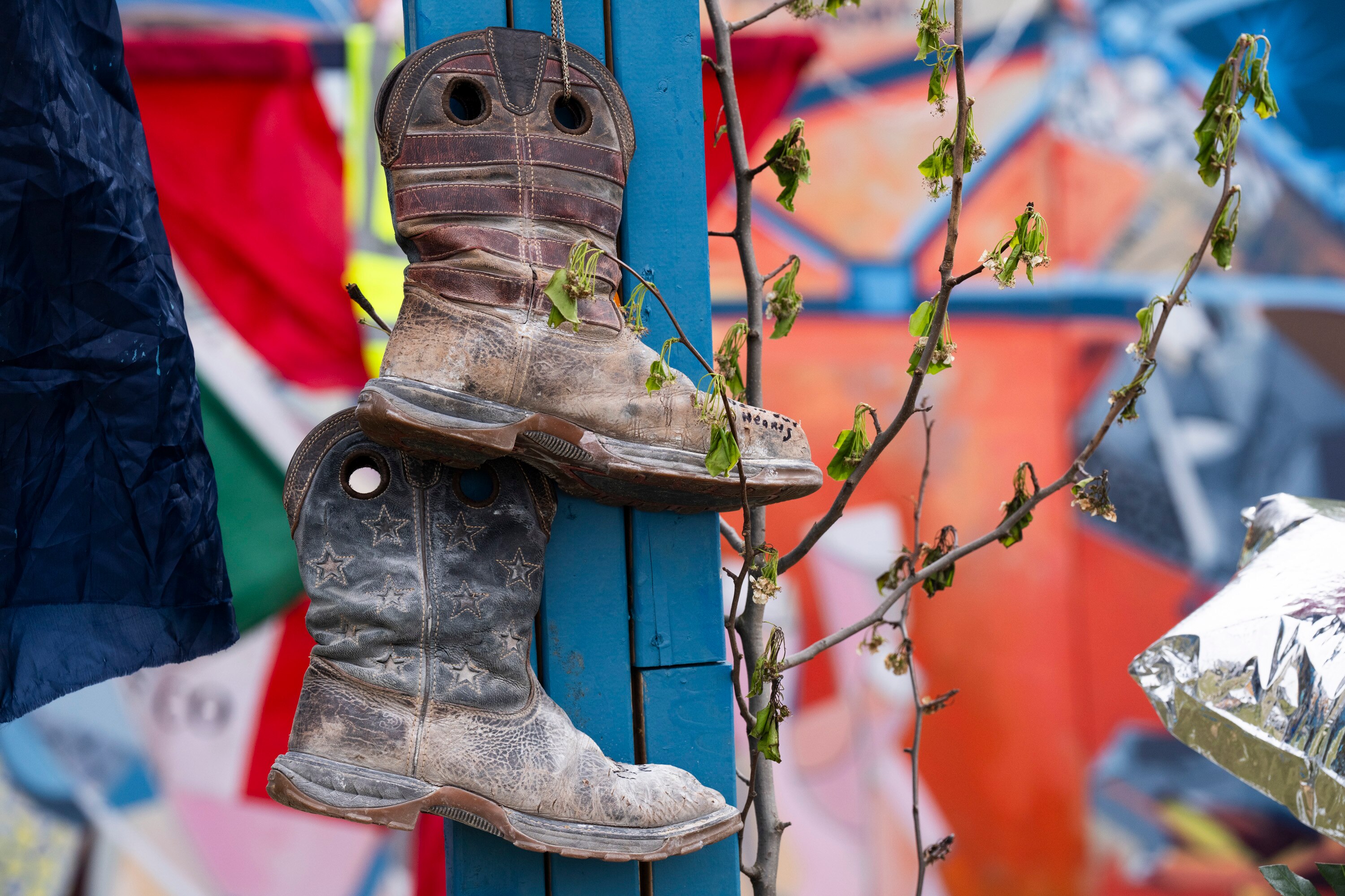 Boots hang from a cross to honor the victims of the Key Bridge Collapse at a memorial on April 6, 2024.
