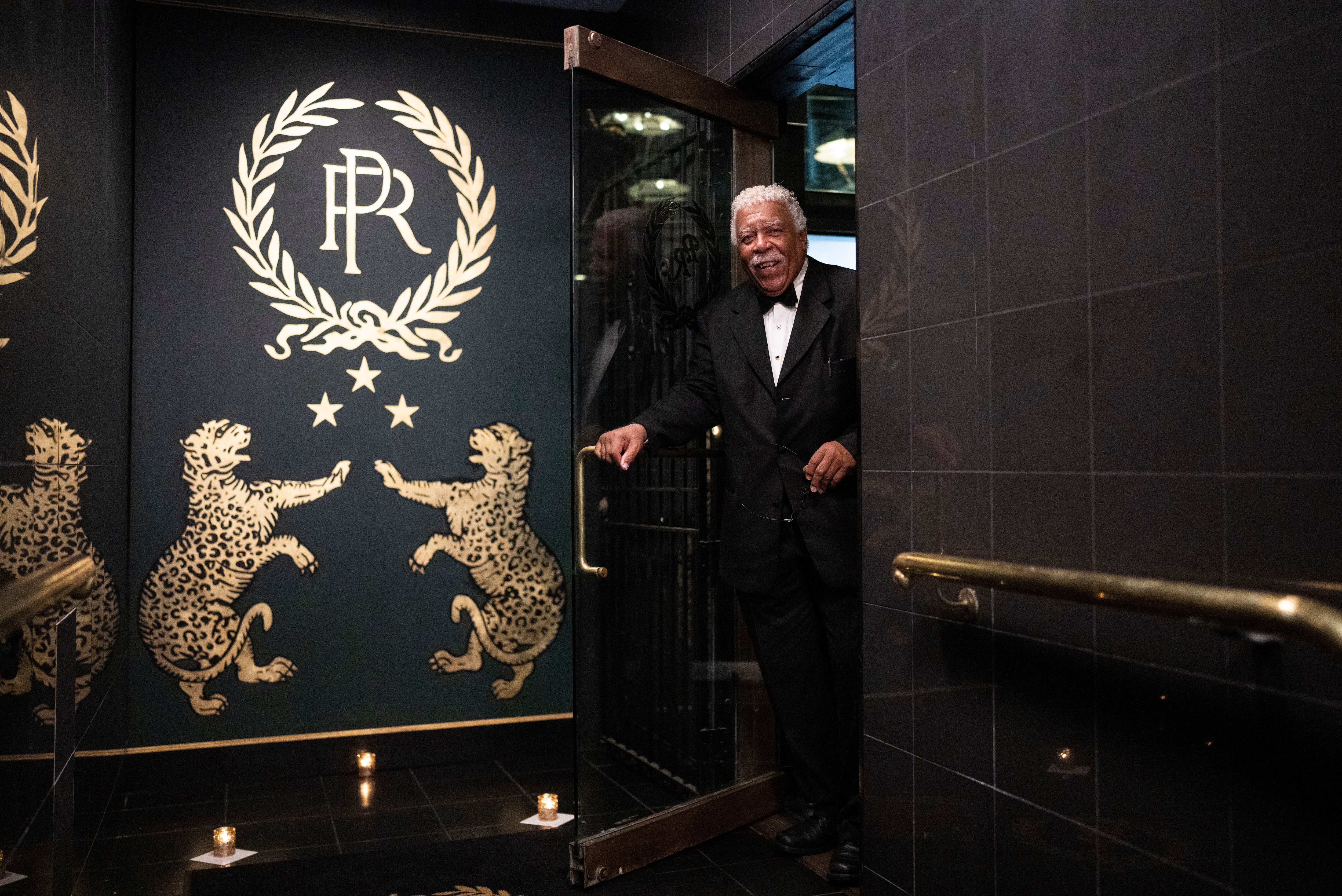 Waiter Aaron Day stands at the entrance of The Prime Rib in Baltimore.