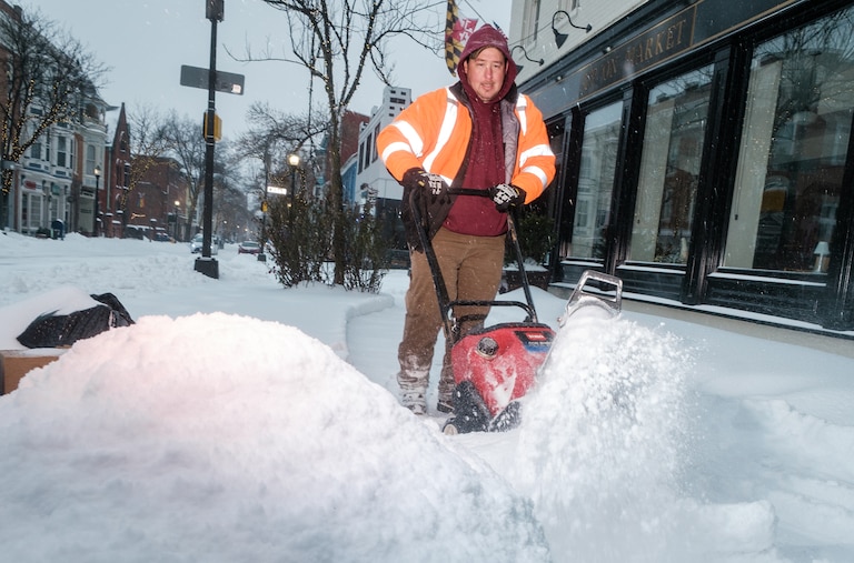 Businesses on Market Street working to get sidewalks cleared as the afternoon sleet adds to the snow in Frederick City, Jan. 25, 2026.