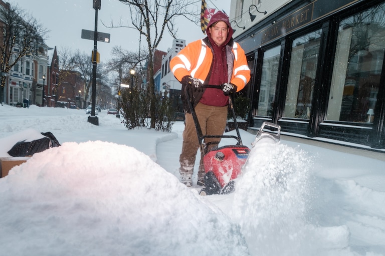 Businesses on Market Street working to get sidewalks cleared as the afternoon sleet adds to the snow in Frederick City, Jan. 25, 2026.